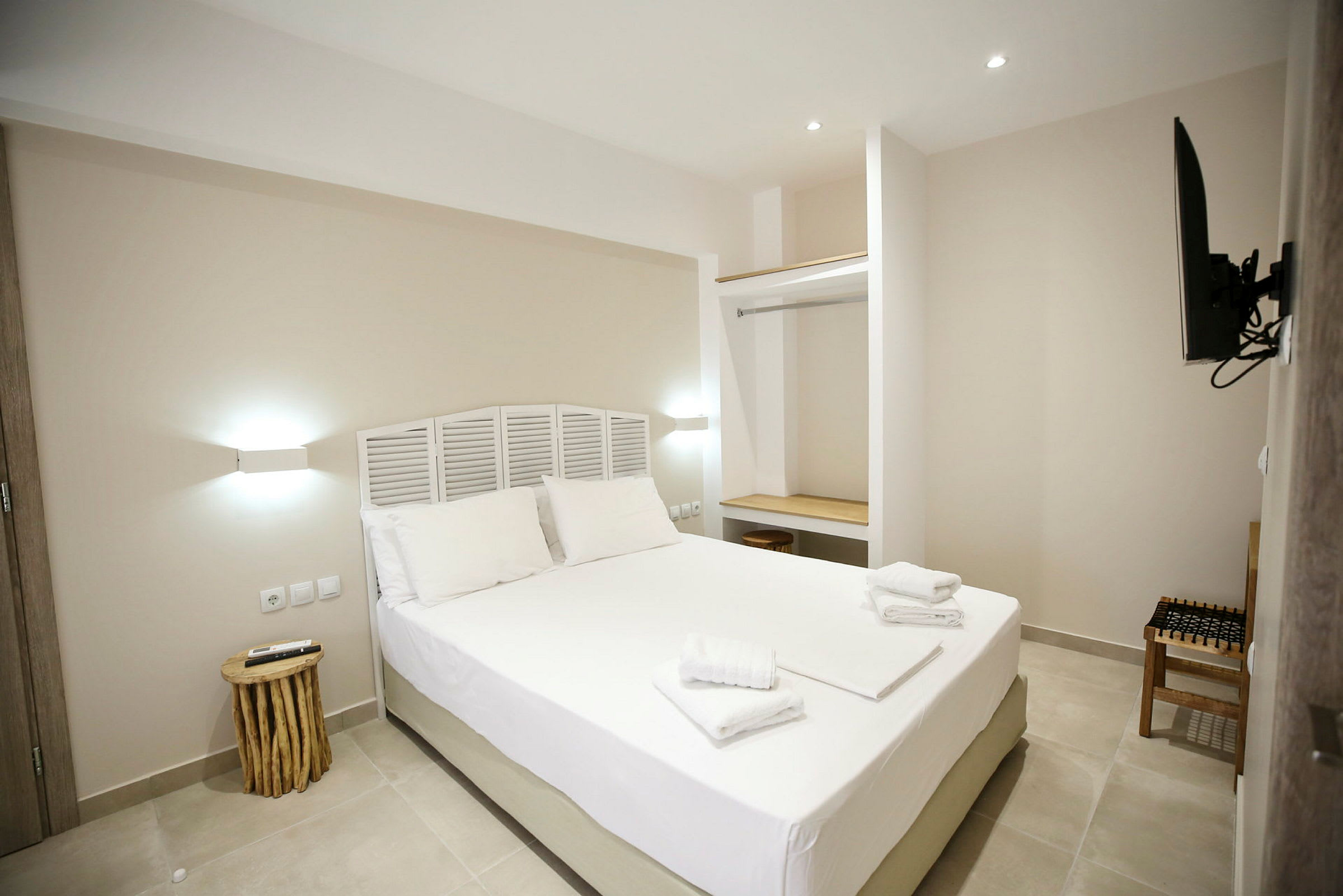 Moderne hotelværelse med en dobbeltseng, minimalistisk indretning og hvide vægge. (AI-genereret tekst)
