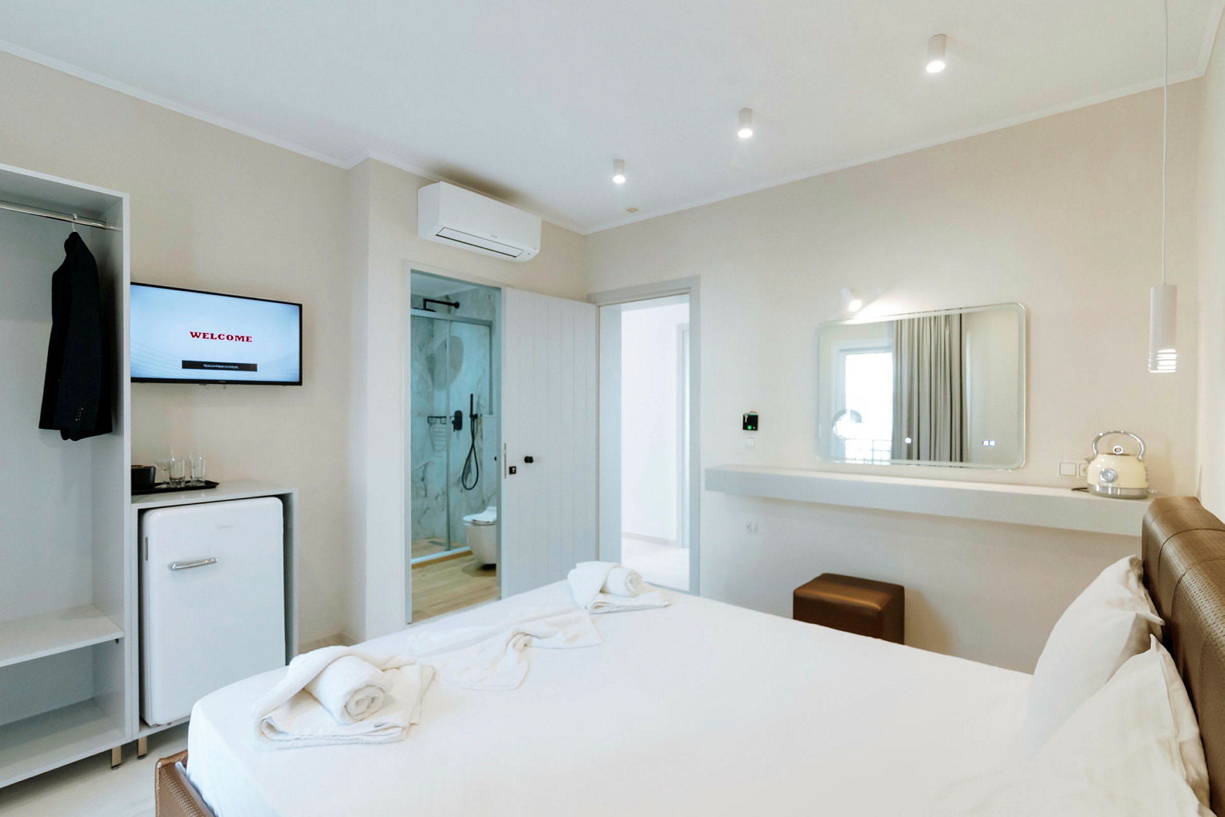Moderne hotelværelse med seng, spejl og badeværelse. (AI-genereret tekst)