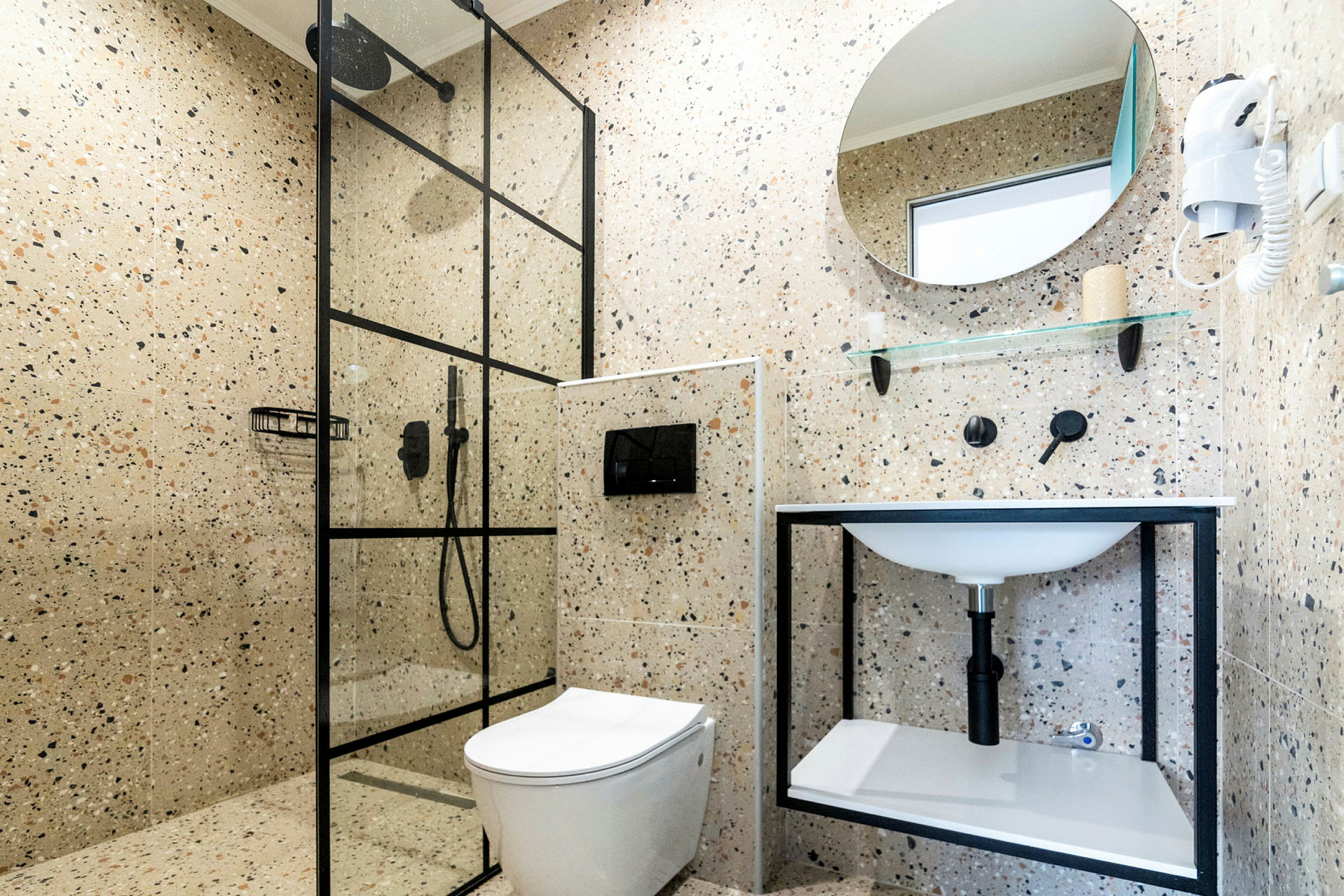 Et moderne badeværelse med bruser, toilet og håndvask. (AI-genereret tekst)