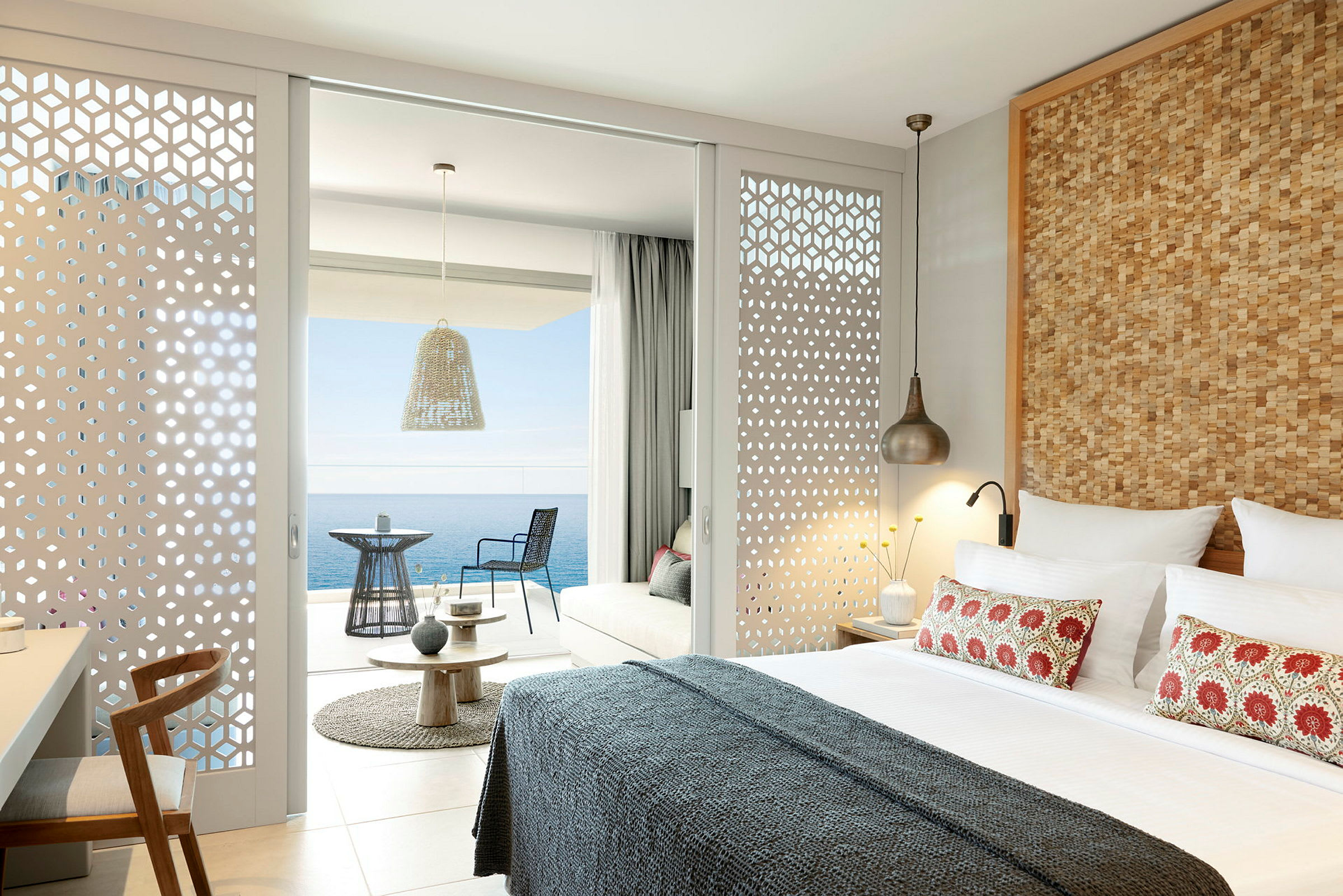 Moderne indrettet hotelværelse med udsigt over havet fra en møbleret balkon. (AI-genereret tekst)