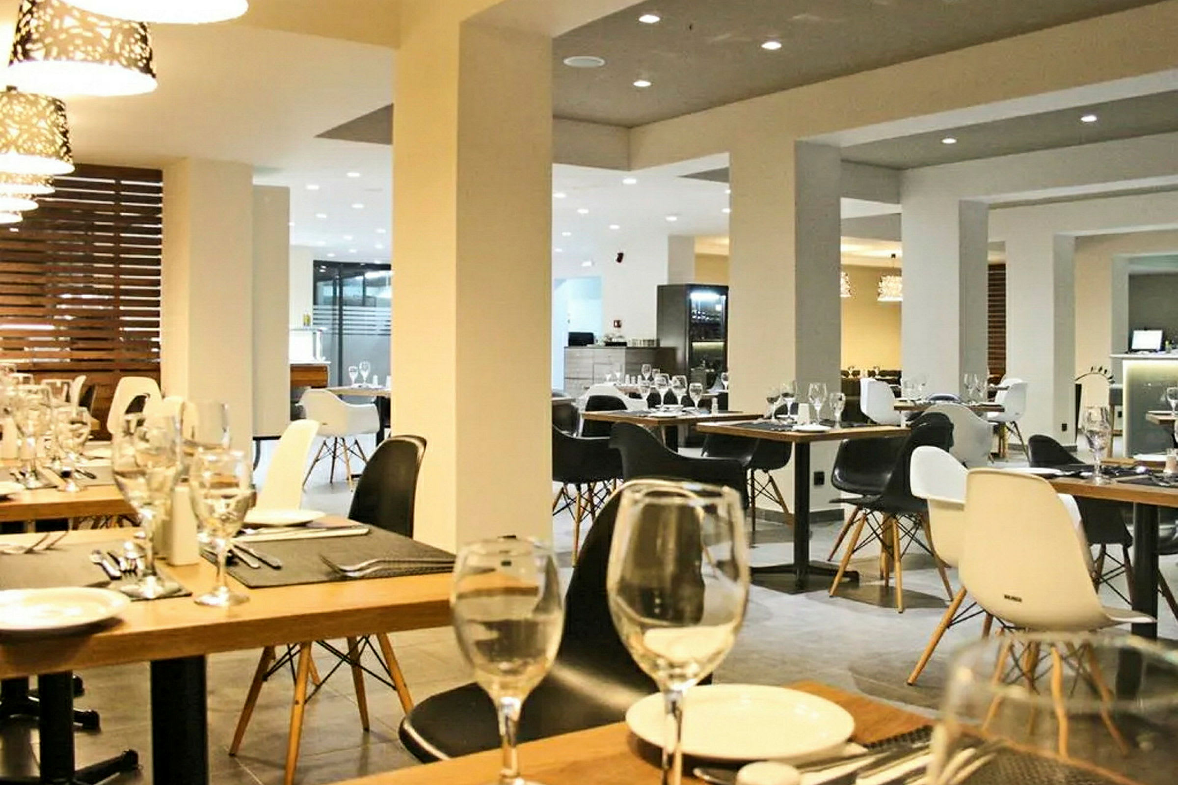Billede af et moderne restaurantinteriør med dækkede borde og elegant belysning. (AI-genereret tekst)