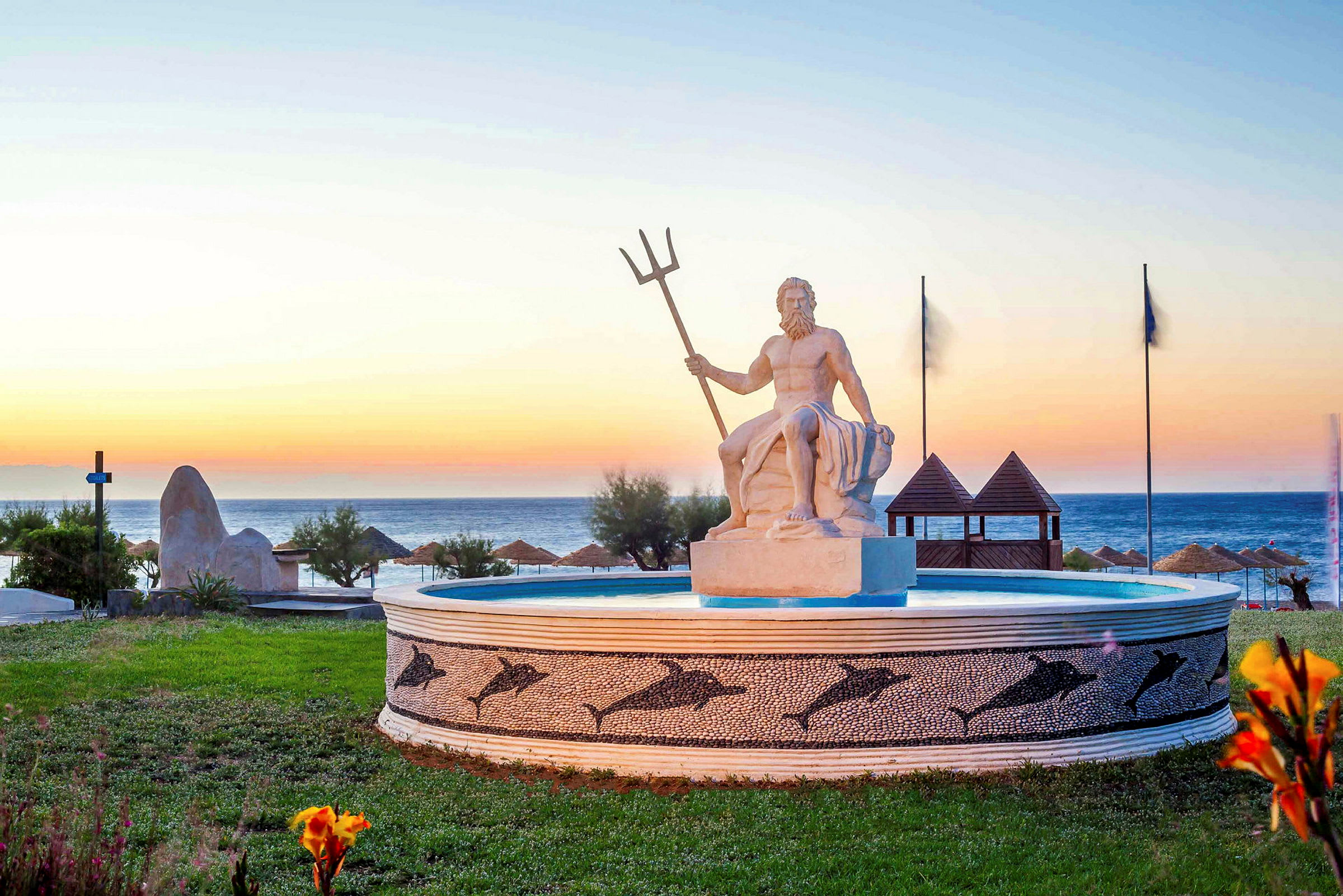Statue af Poseidon ved en springvand tæt på havet ved solnedgang. (AI-genereret tekst)
