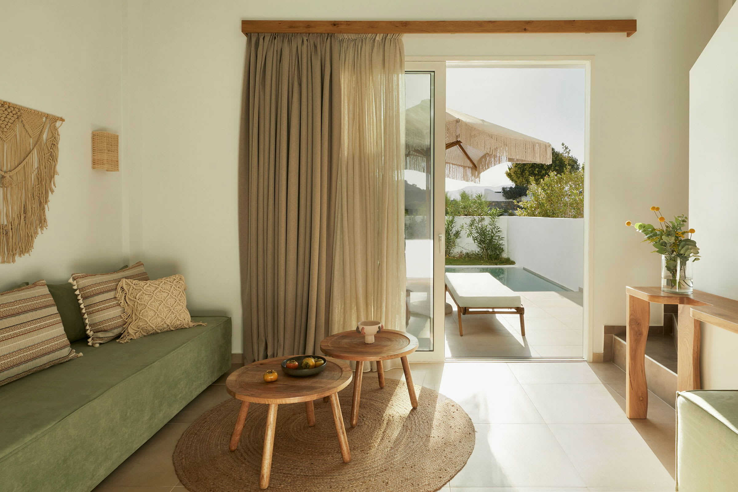 Moderne rum med grøn sofa, træmøbler og en glasdør der fører til en terrasse med pool. (AI-genereret tekst)