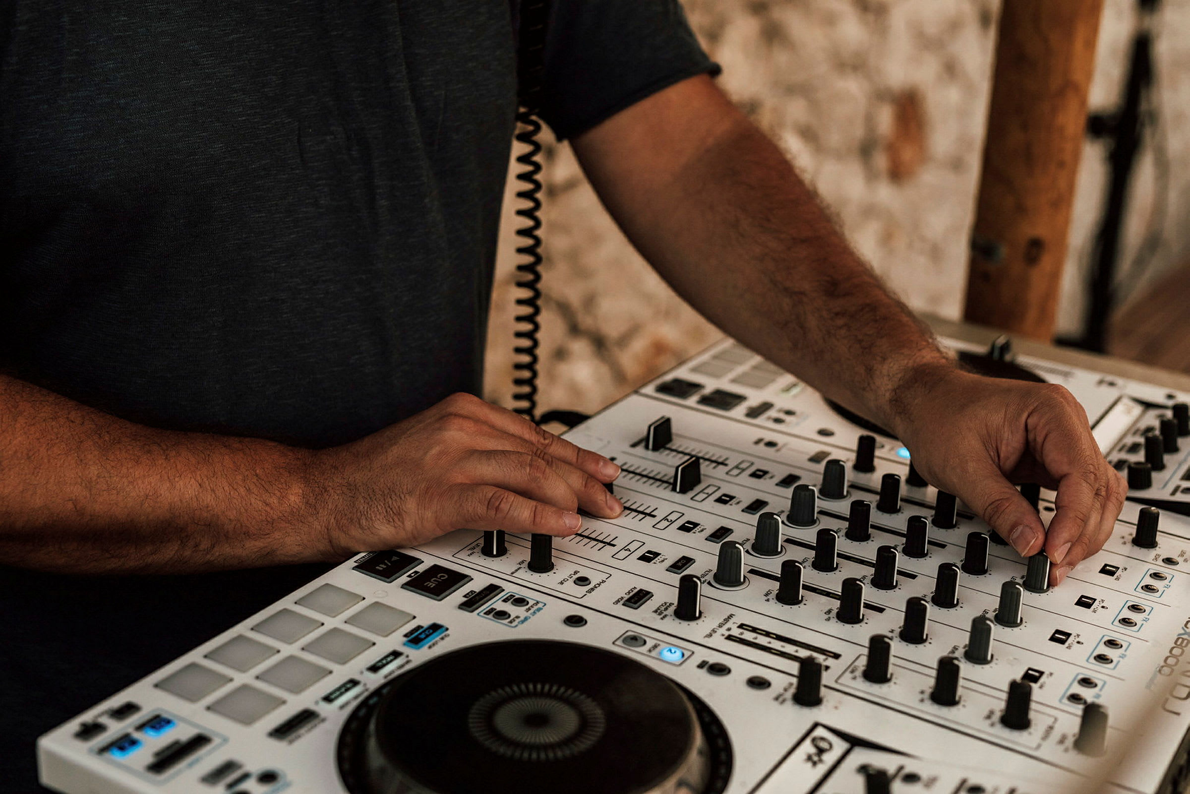 En person justerer kontroller på en DJ-mixer. (AI-genereret tekst)