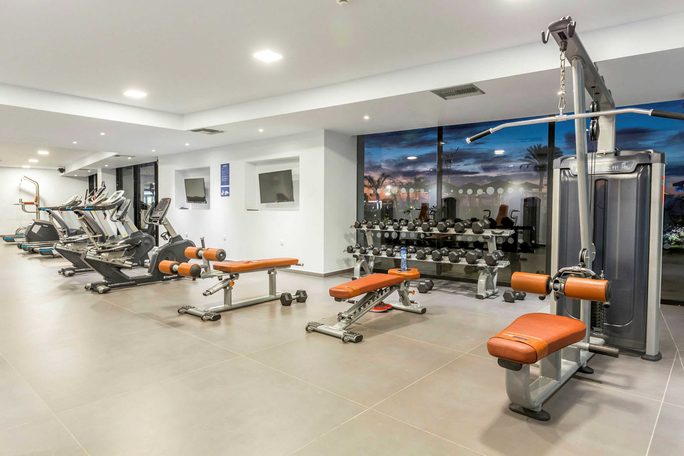Moderne fitnesscenter med forskellige træningsmaskiner og frie vægte. (AI-genereret tekst)