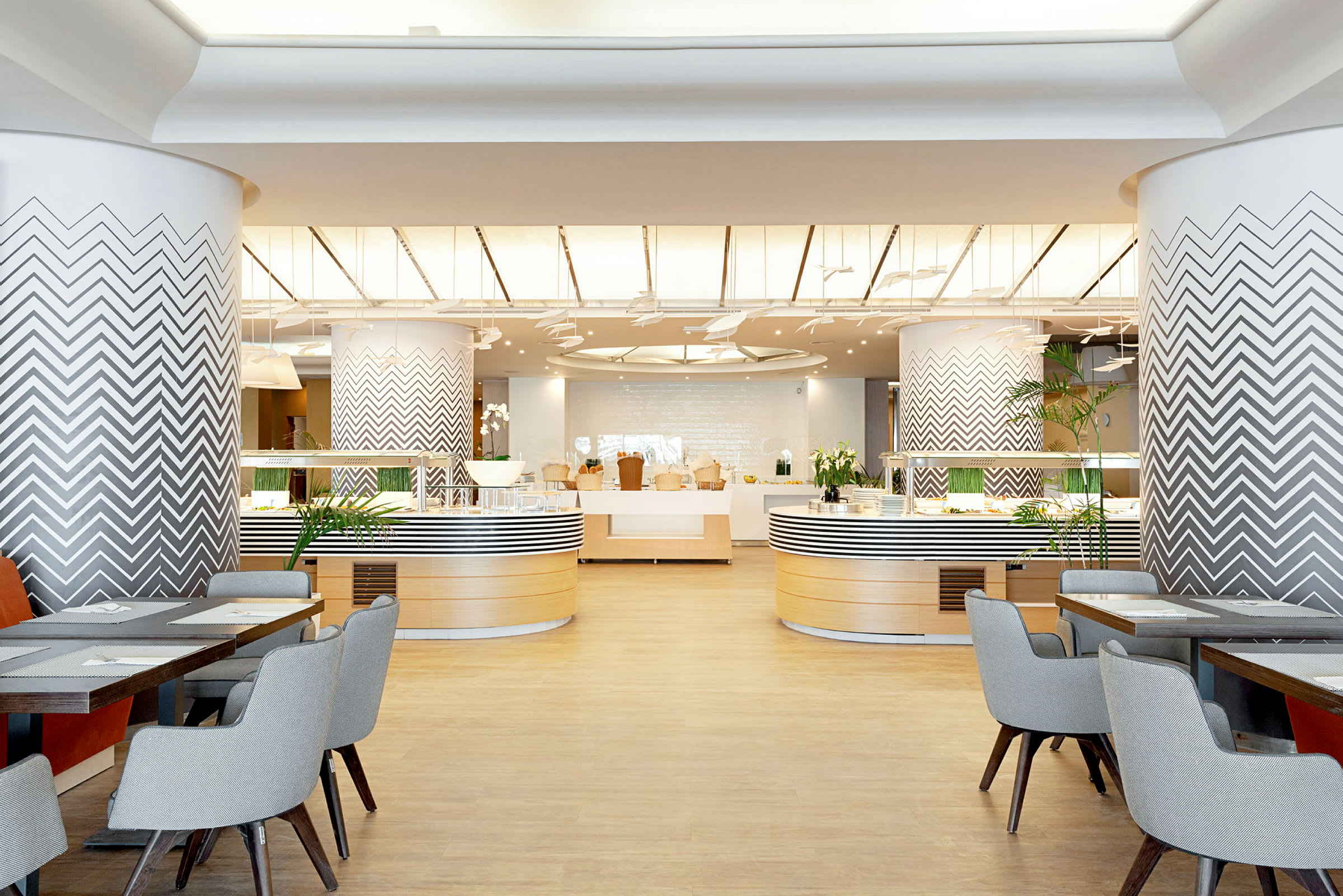 Interiør af en moderne restaurant med dekorative søjler og siddepladser. (AI-genereret tekst)