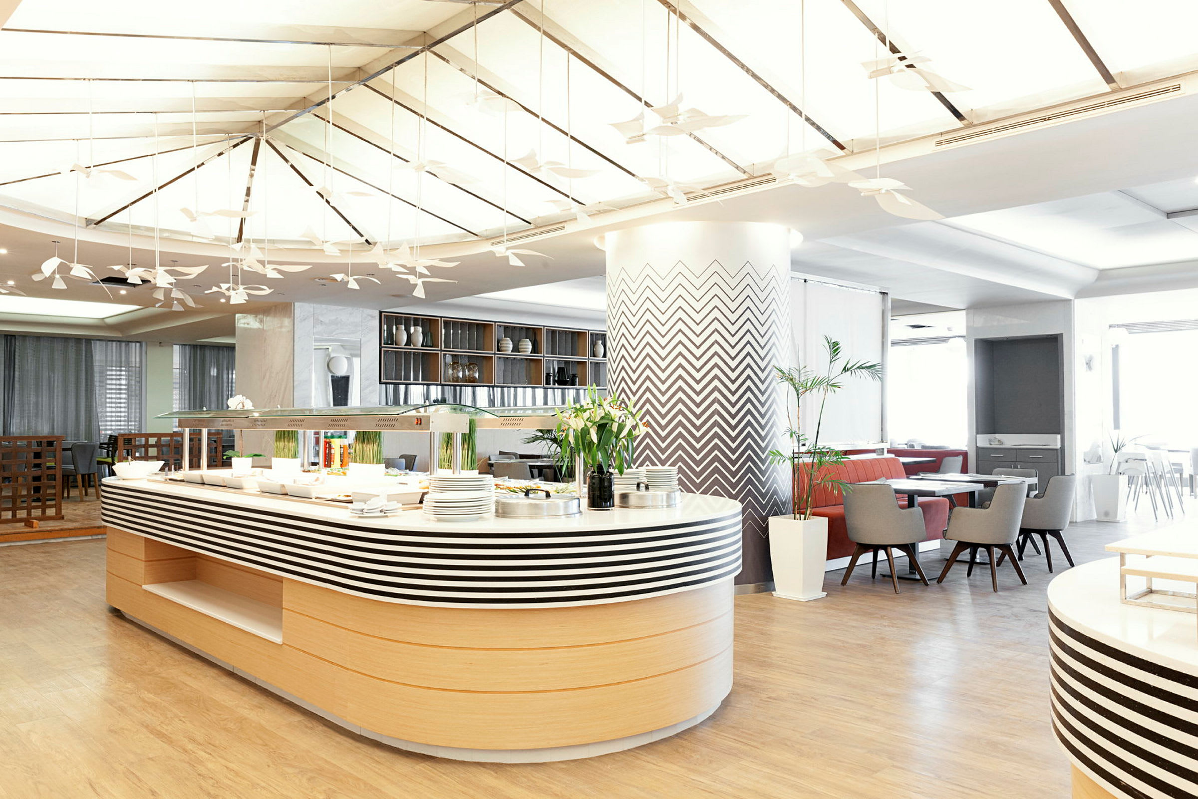 Moderne restaurant med buffetbord og siddepladser. (AI-genereret tekst)