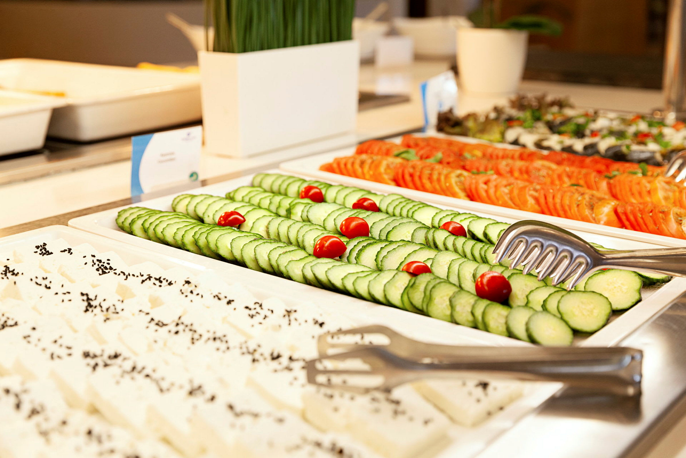 Buffet med skiver af agurk, tomat og fetaost. (AI-genereret tekst)