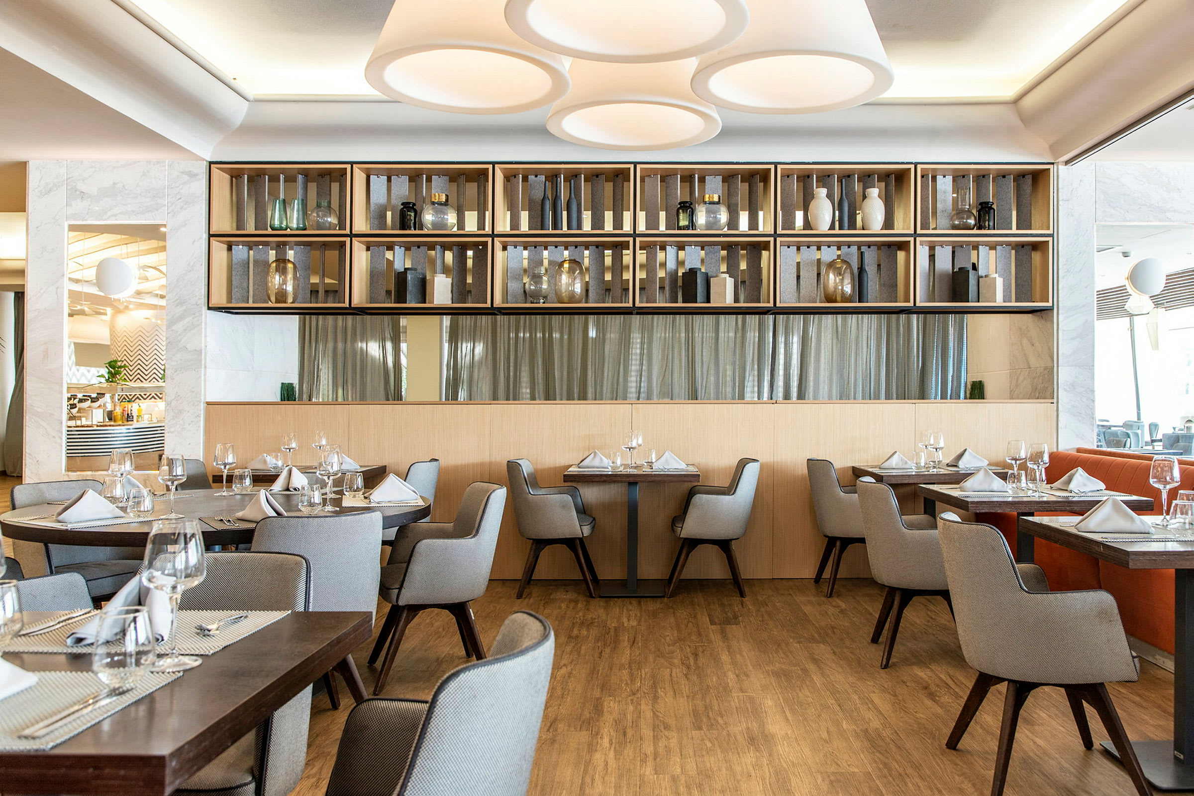 Interiør af en elegant restaurant med opdækkede borde og moderne indretning. (AI-genereret tekst)