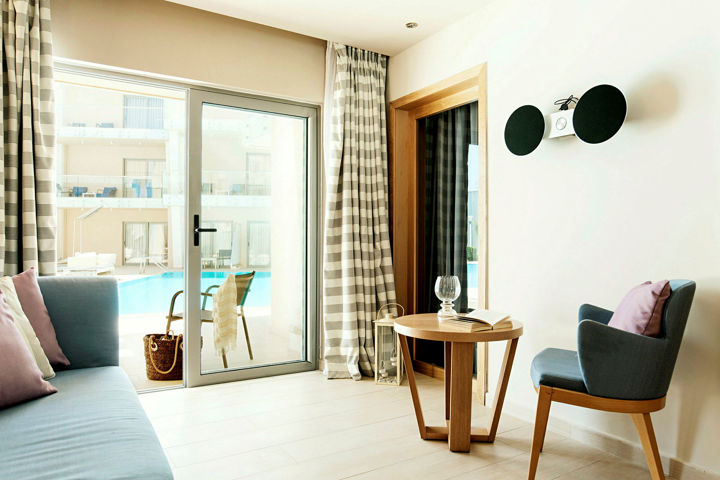 Et hotelværelse med siddeområde og udsigt til poolen. (AI-genereret tekst)