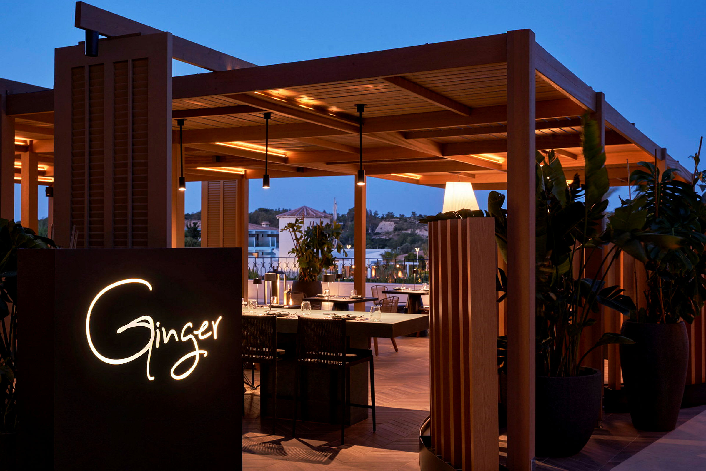 Restauranten Ginger med trædesign under dæmpet belysning, omgivet af planter. (AI-genereret tekst)