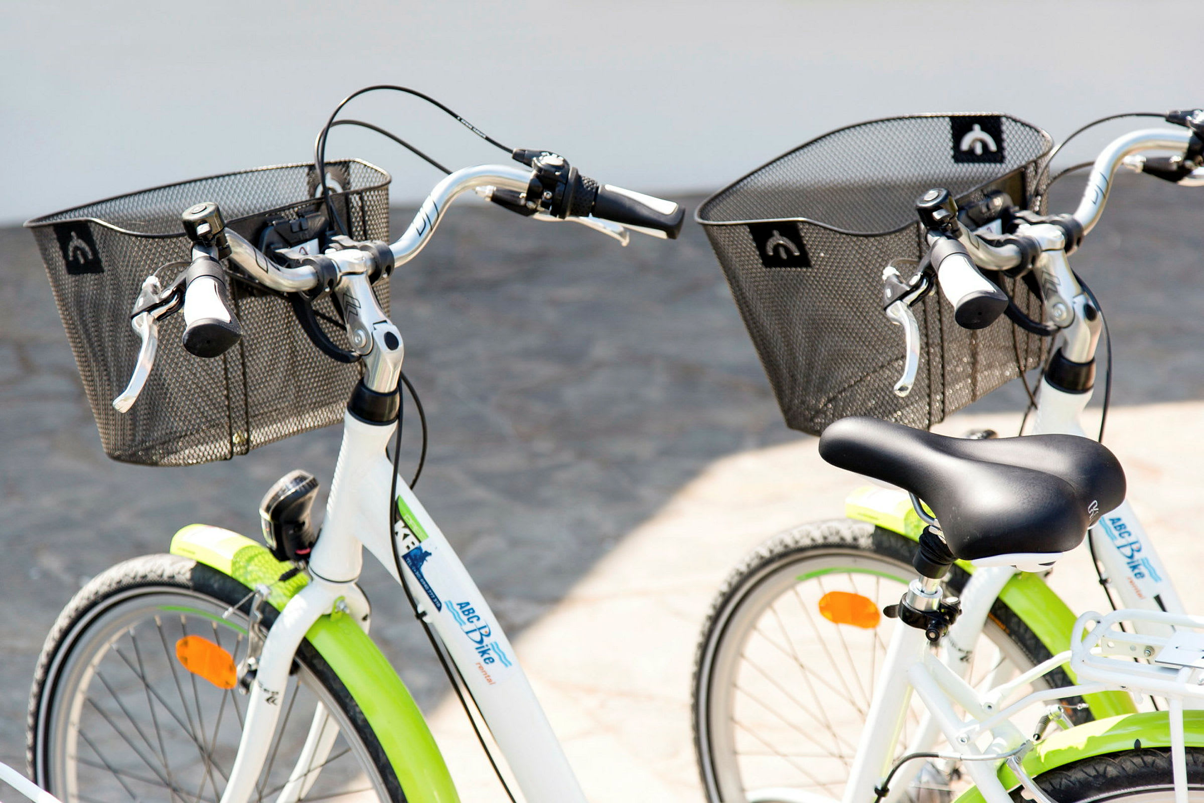To hvide cykler med sorte sadler og kurve vises. (AI-genereret tekst)