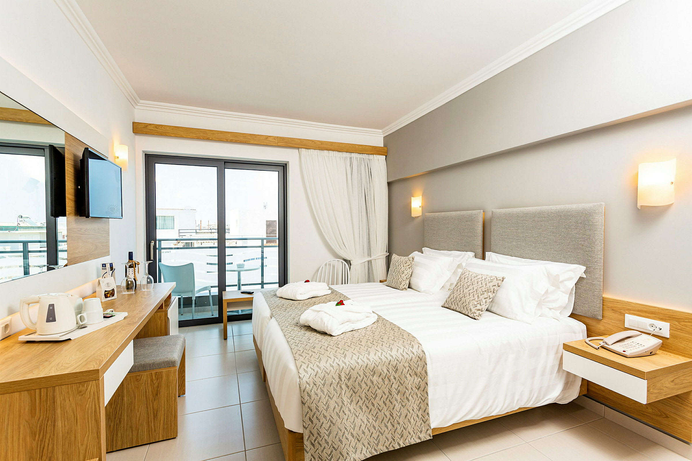 Moderne hotelværelse med dobbeltseng, skrivebord og balkon. (AI-genereret tekst)