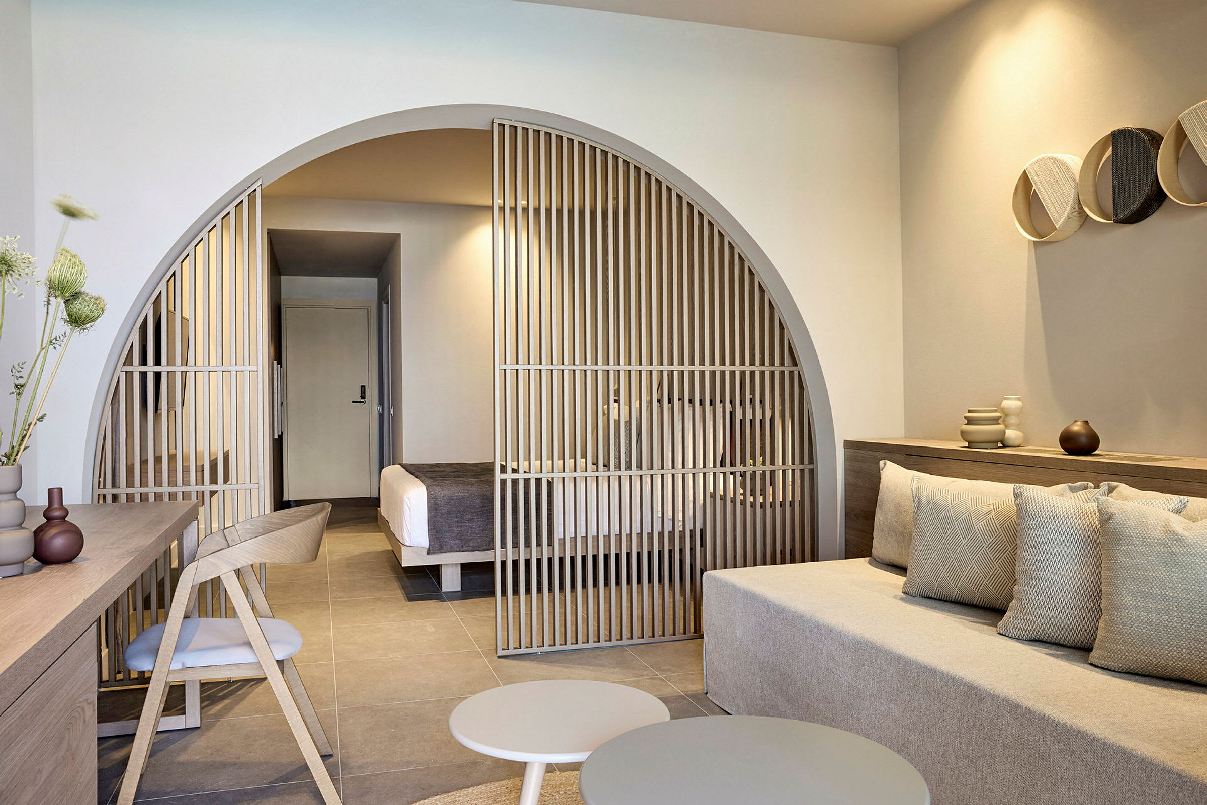 Moderne hotelværelse med siddeområde og skillevæg mod soveområdet. (AI-genereret tekst)