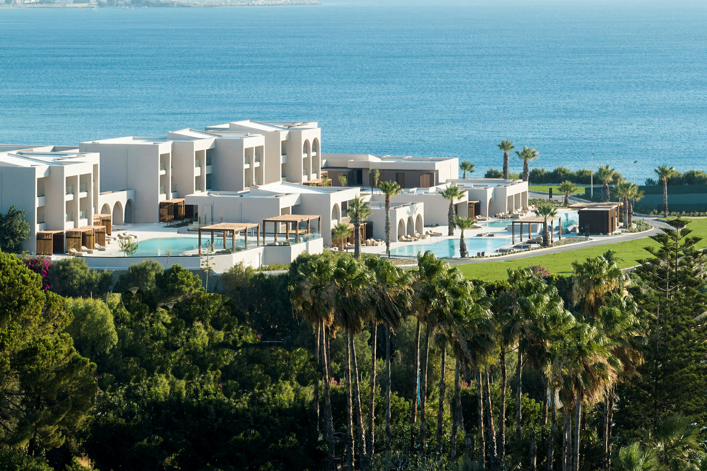 Moderne resort med pools, grønne områder og havet i baggrunden. (AI-genereret tekst)
