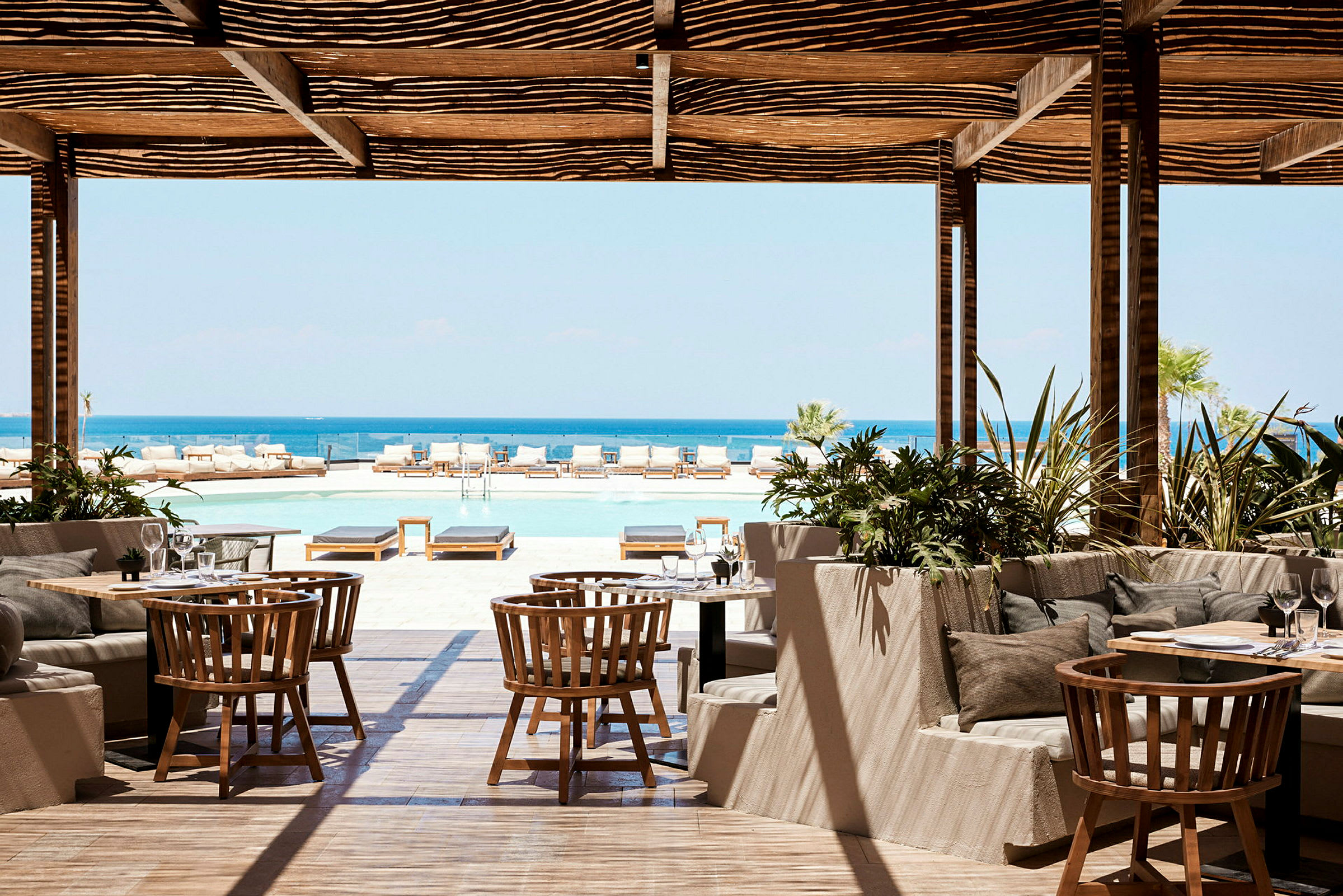 Restaurant med udsigt over en swimmingpool og havet. (AI-genereret tekst)