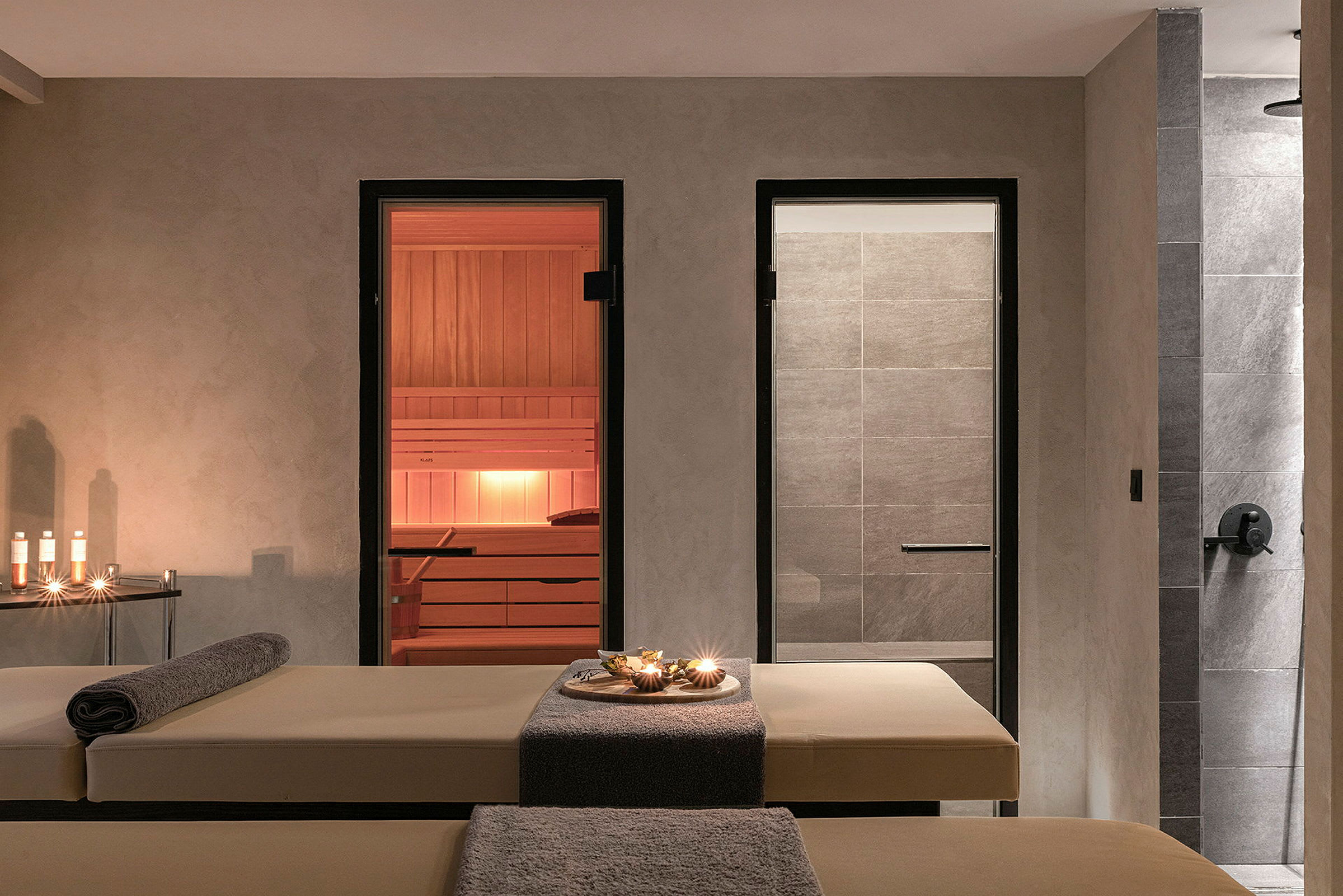 Billede af et spa-rum med massagebænke, lys og en sauna. (AI-genereret tekst)