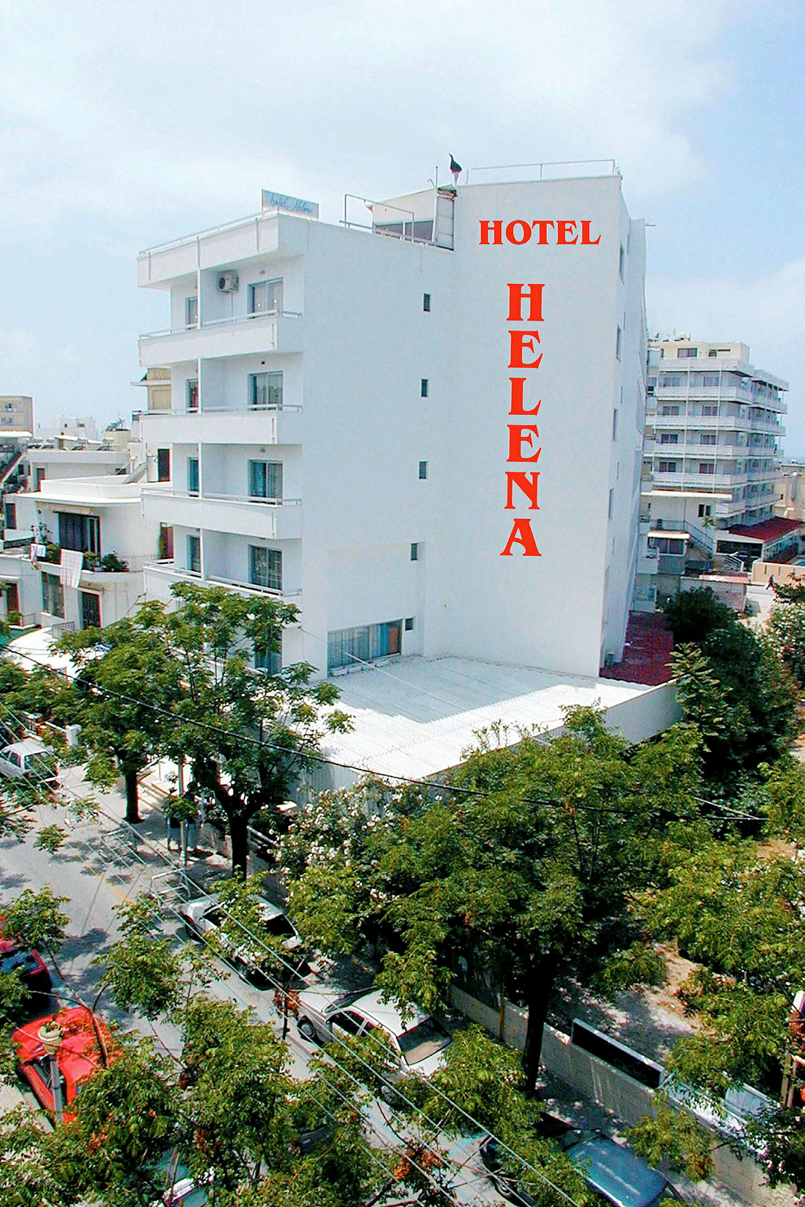 Hvid hotelbygning med navnet 'Hotel Helena' skrevet med røde bogstaver. (AI-genereret tekst)