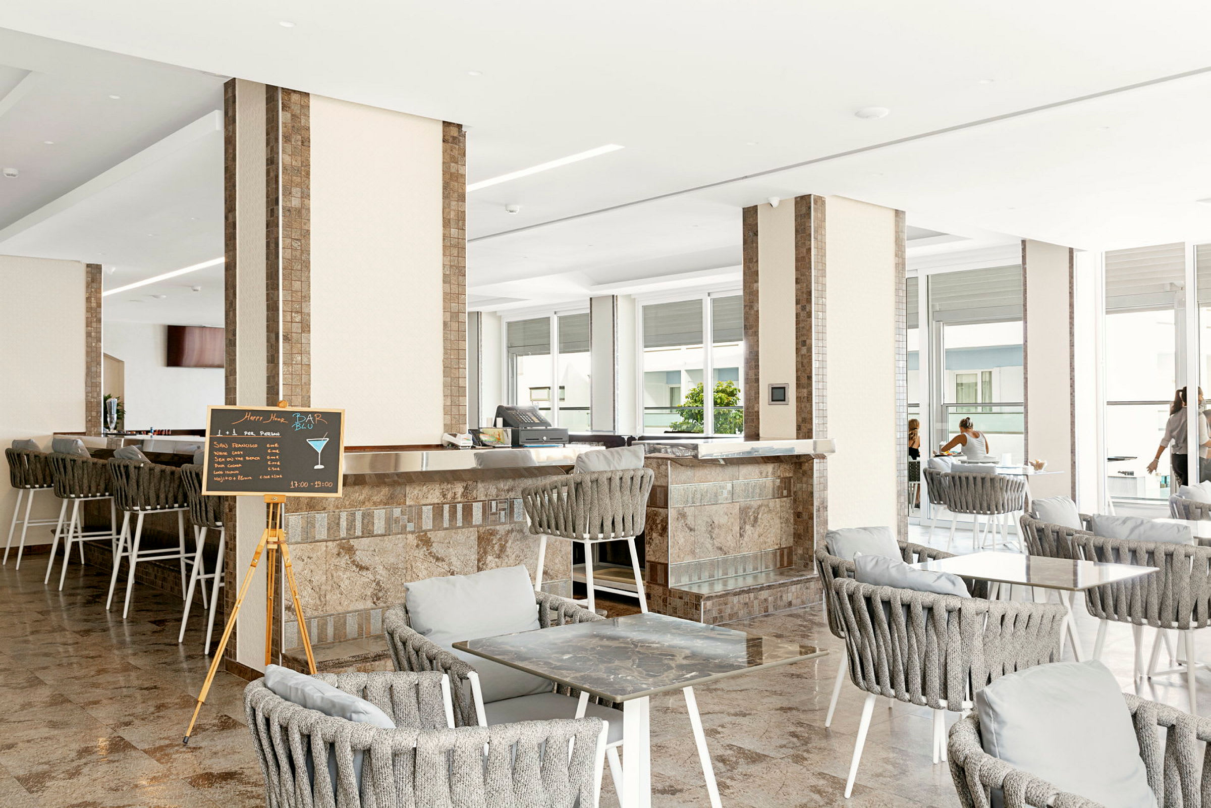 Interiør af en bar/lounge med siddepladser og borde. (AI-genereret tekst)