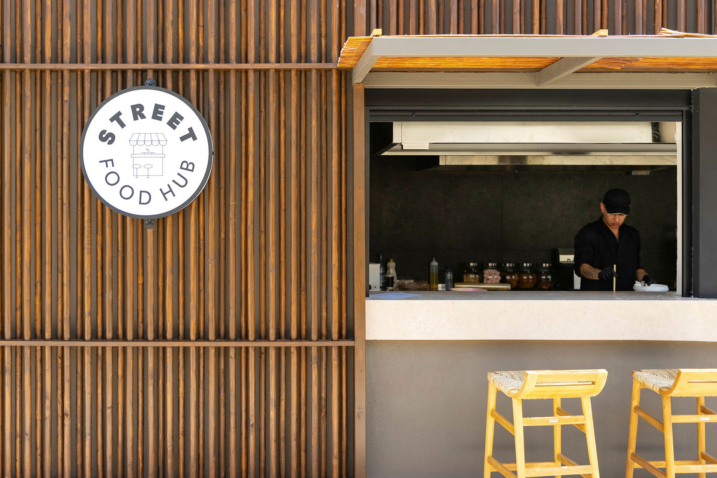 Udsigt til en madservering med en åben serveringsluge og et skilt, der viser 'Street Food Hub'. (AI-genereret tekst)