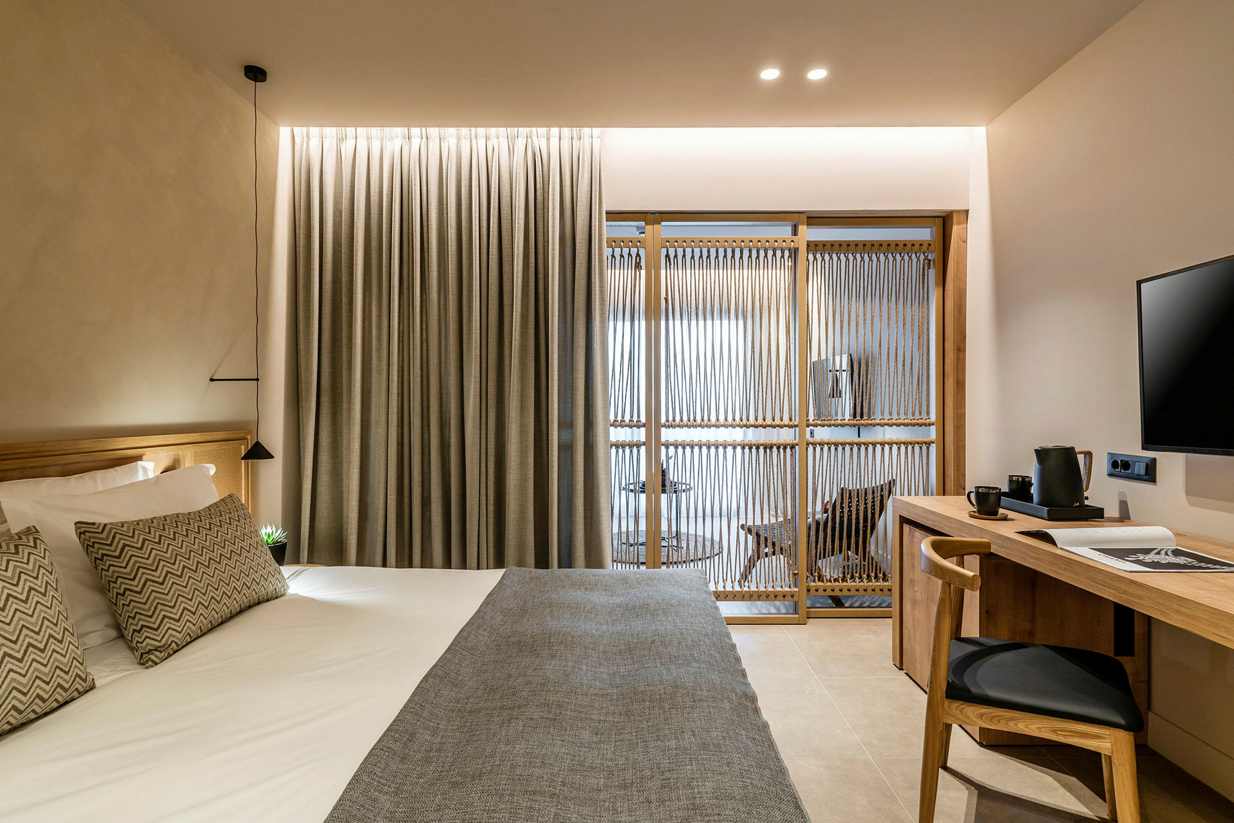 Hotelværelse med moderne indretning, inklusive seng, skrivebord og skillevæg. (AI-genereret tekst)