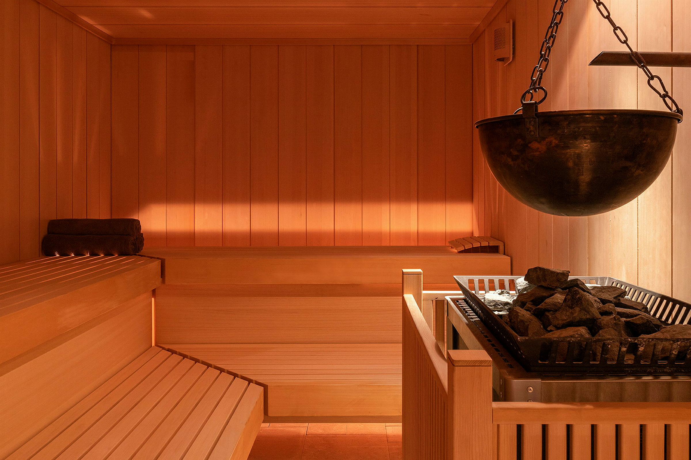 En sauna med træbænke og et varmeaggregat med sten. (AI-genereret tekst)