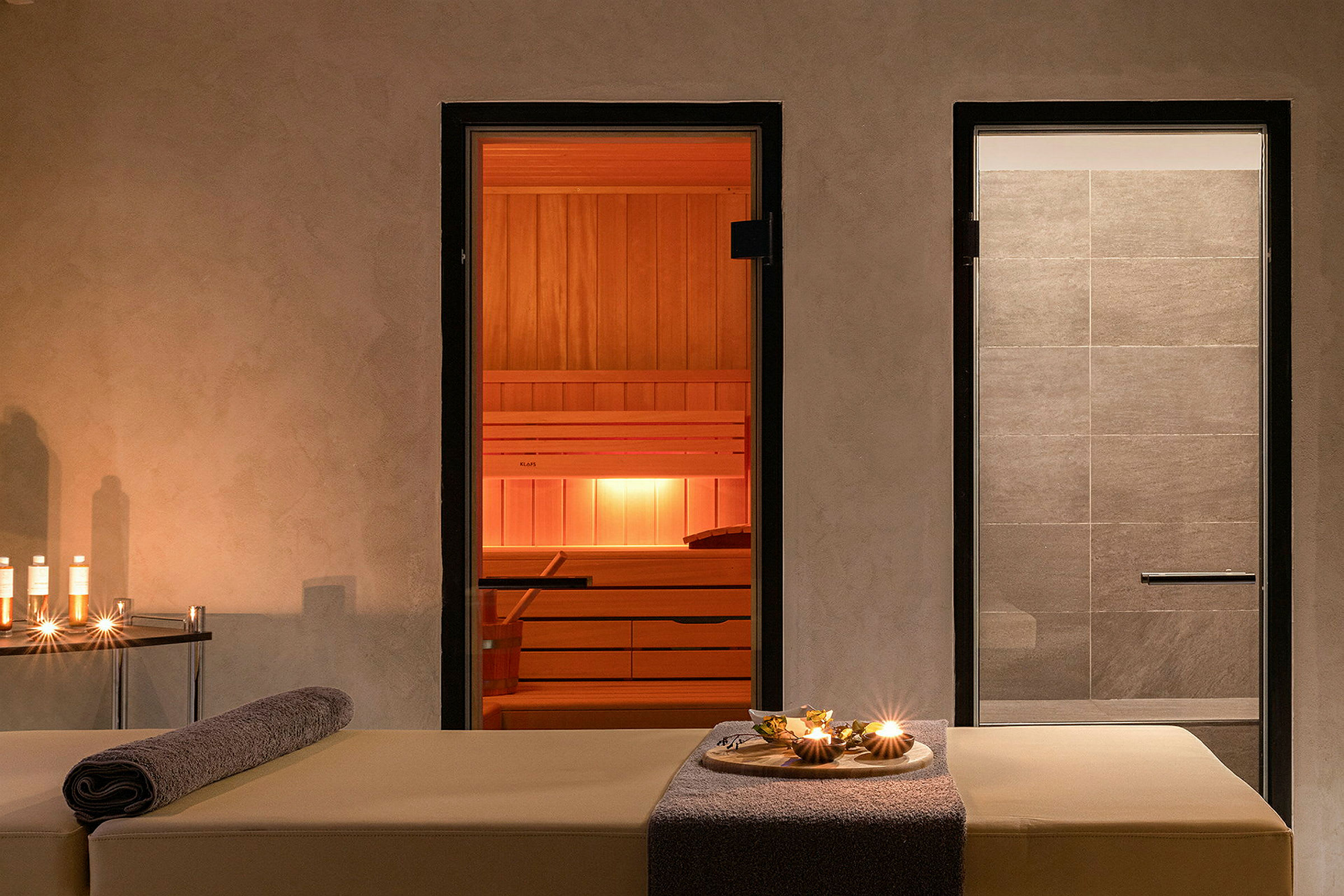 Spaområde med massagebriks, sauna og bruser. (AI-genereret tekst)