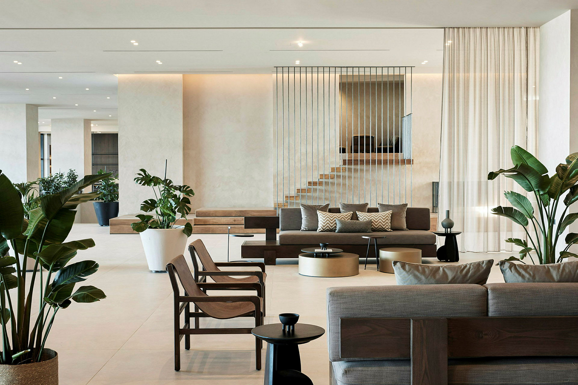 Moderne hotellobby med sofaer, stole og grønne planter. (AI-genereret tekst)