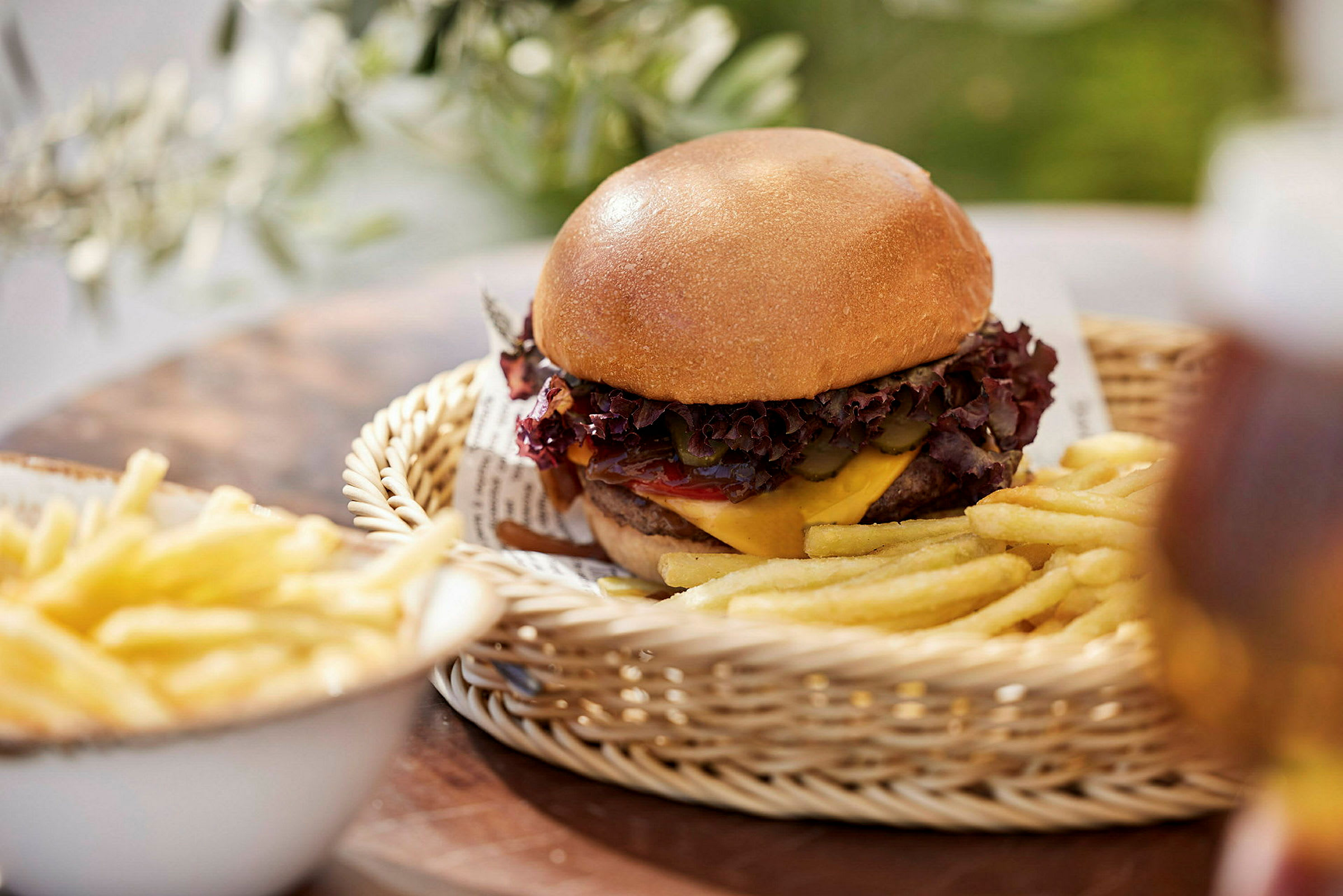 En burger med pommes frites serveret i en kurv. (AI-genereret tekst)