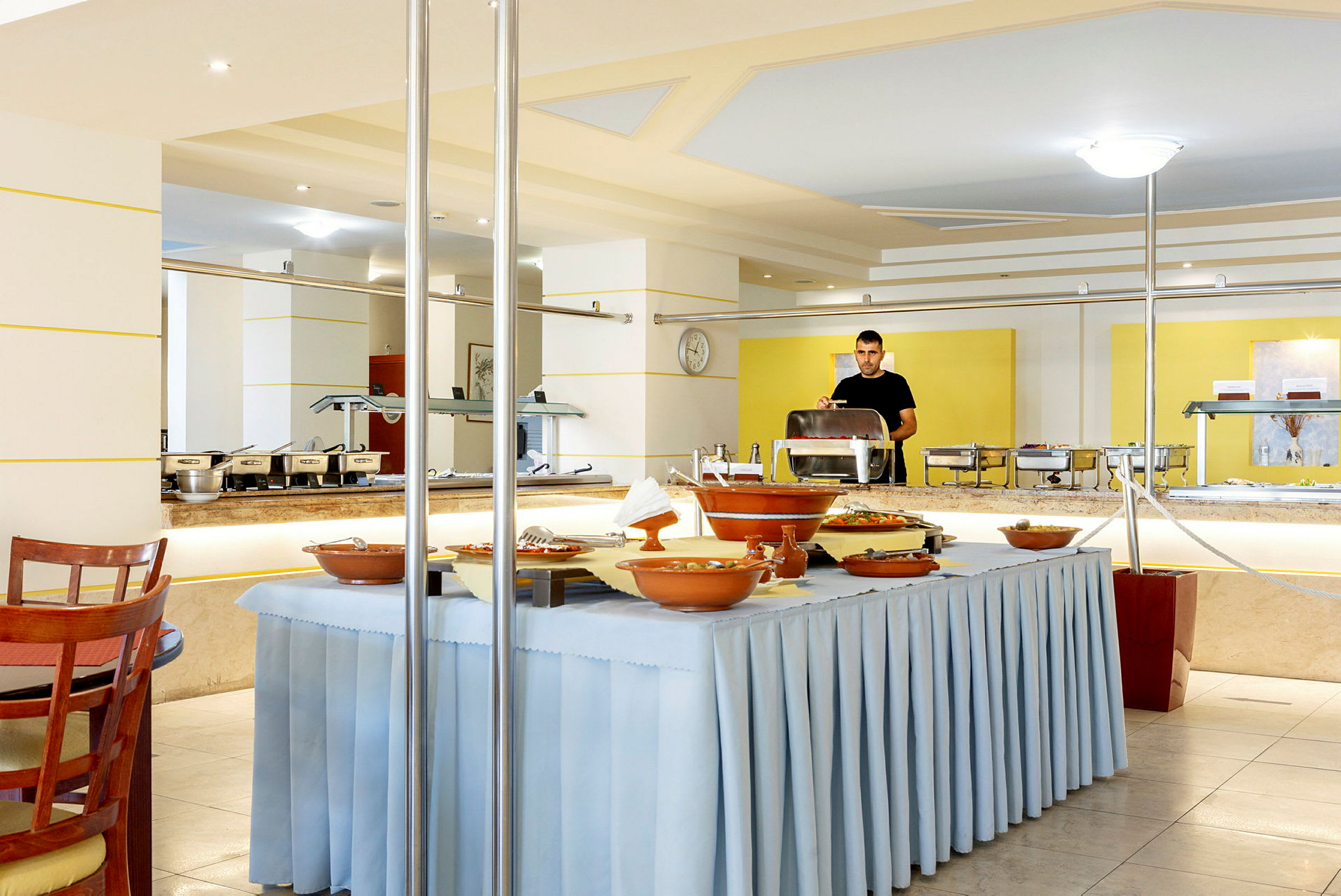 Buffet i en lys restaurant med gul og hvid indretning. (AI-genereret tekst)