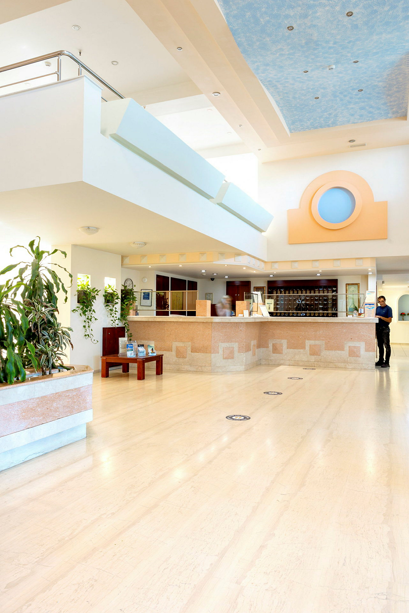 Lobbyområde med reception, planter og interiørdetaljer. (AI-genereret tekst)