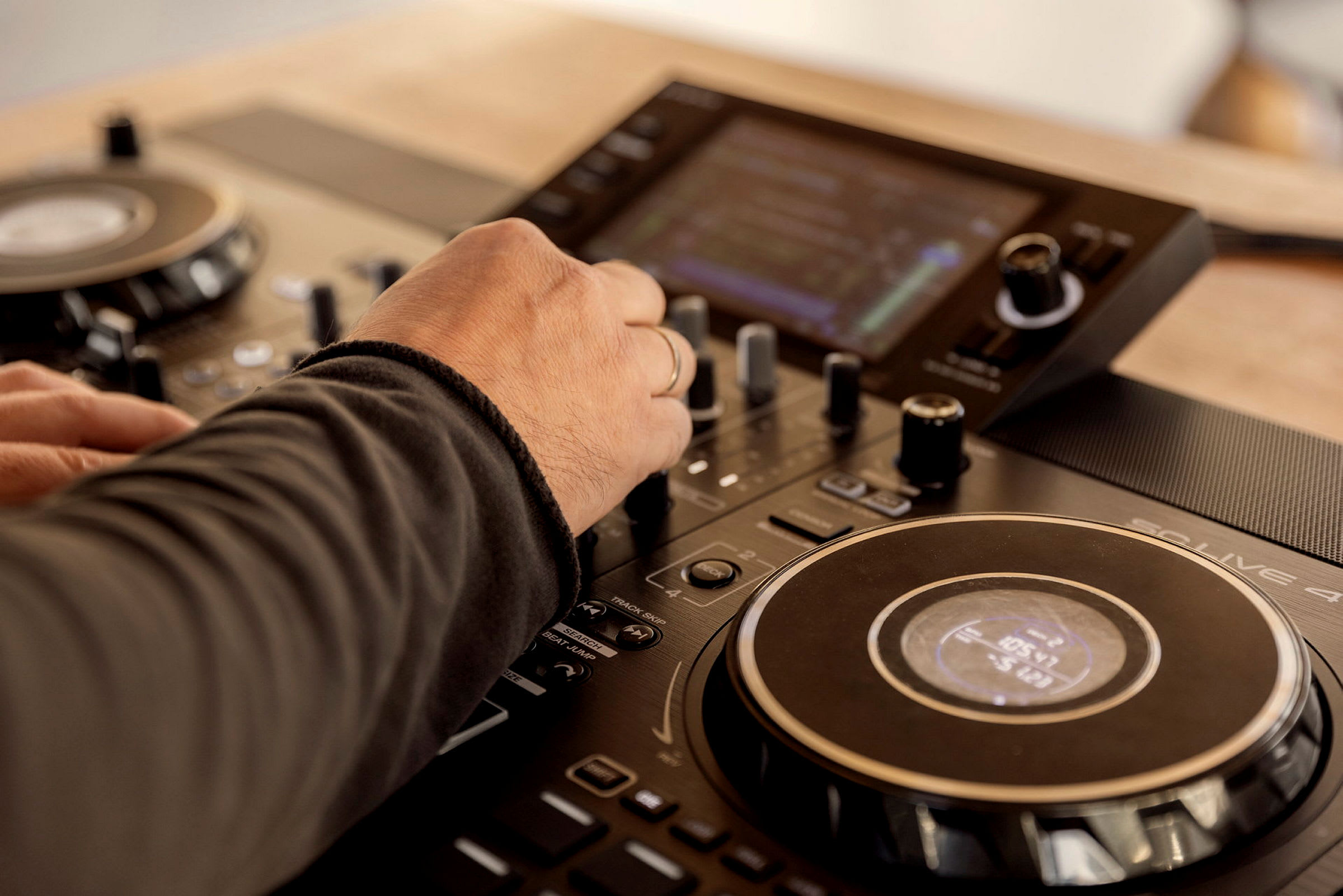 En hånd justerer knapper på en DJ-mixer. (AI-genereret tekst)
