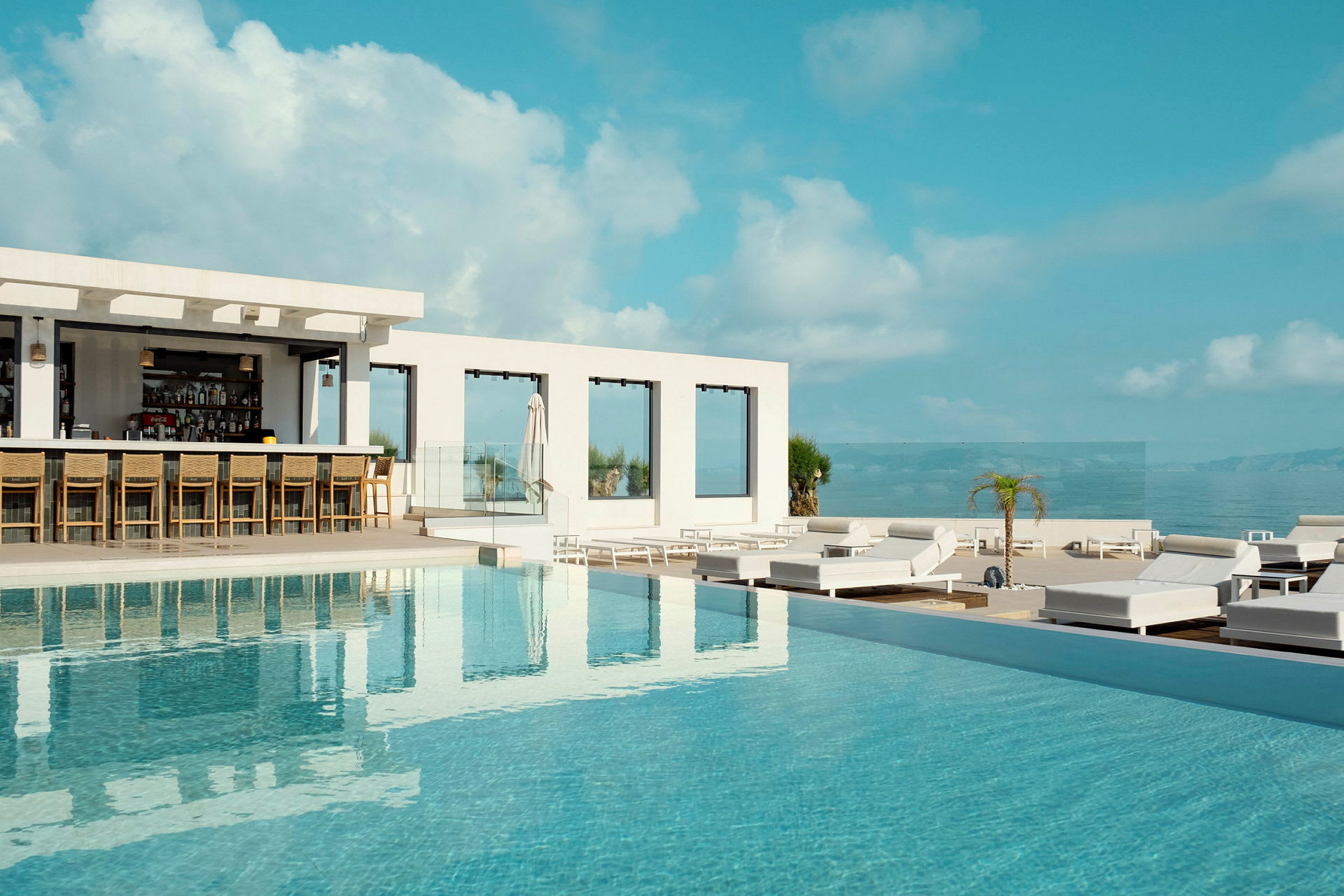 Udendørs swimmingpool ved en resort med en bar og liggestole. (AI-genereret tekst)