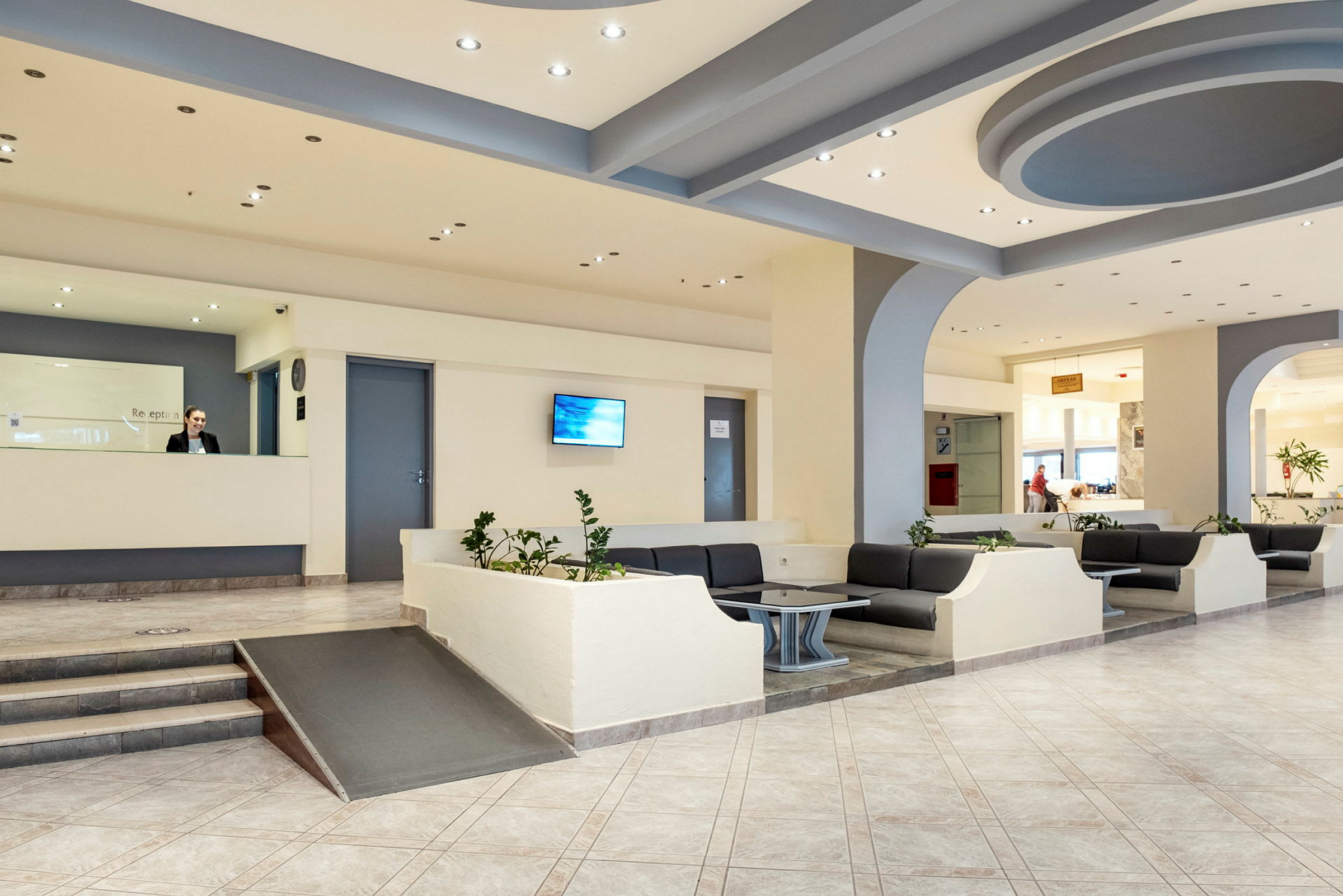 Hotellets foyer med reception og siddepladser. (AI-genereret tekst)