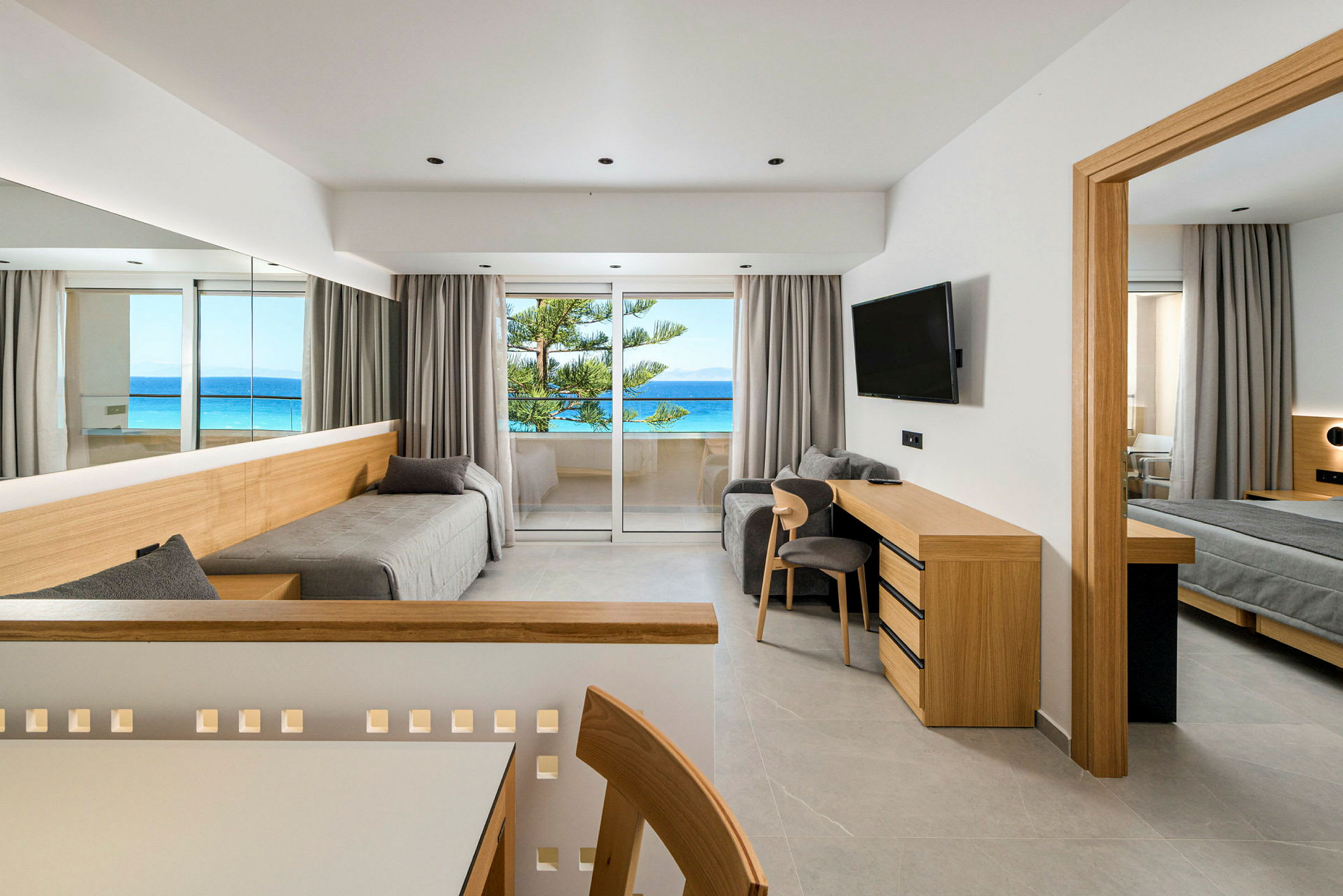 Et moderne hotelværelse med skandinavisk indretning og udsigt over havet fra altanen. (AI-genereret tekst)