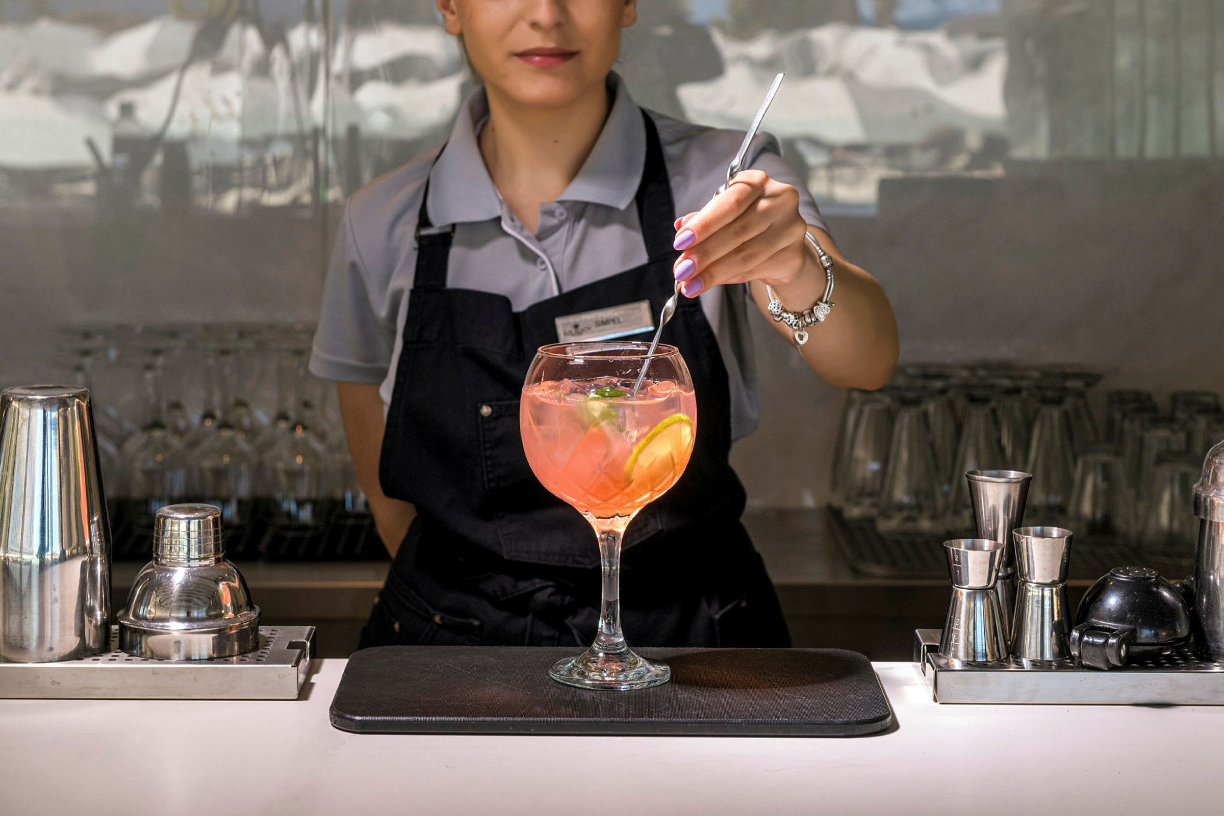 En bartender rører en drink med citronskiver og isterninger. (AI-genereret tekst)