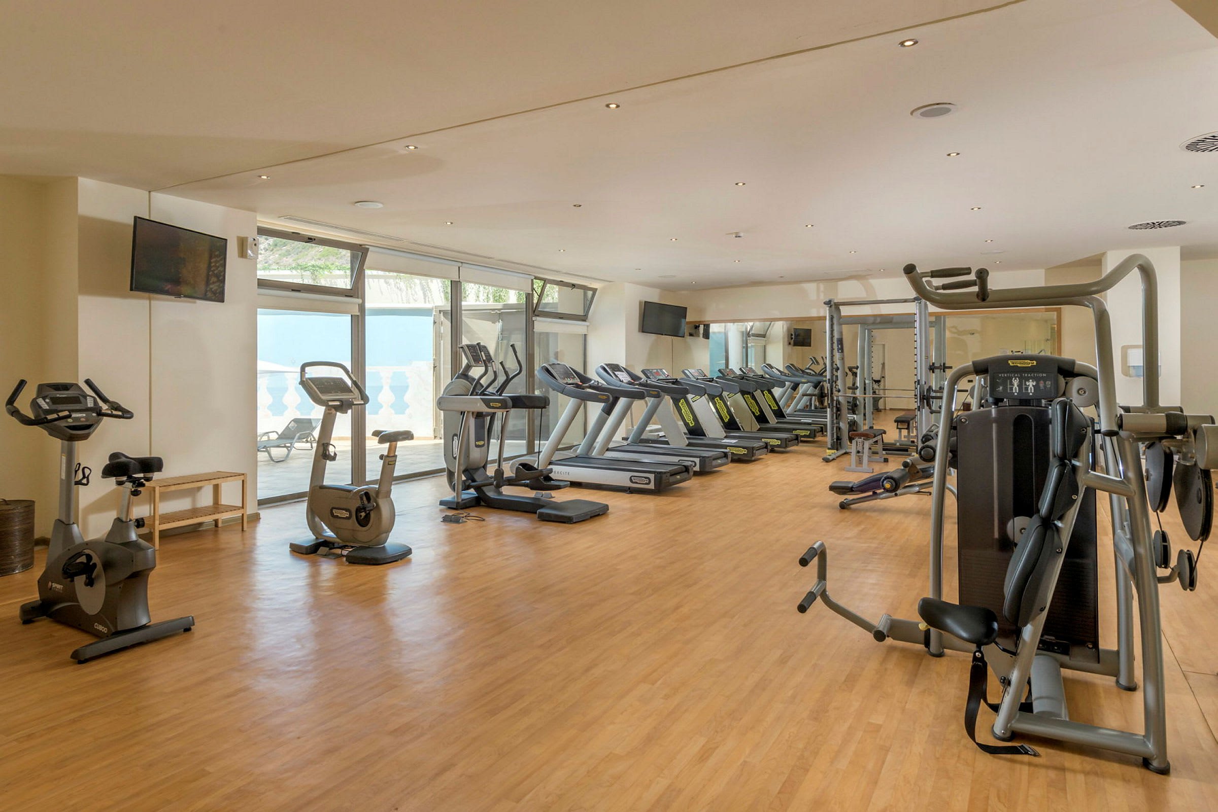 Billede af et fitnesscenter med træningsmaskiner og løbebånd. (AI-genereret tekst)