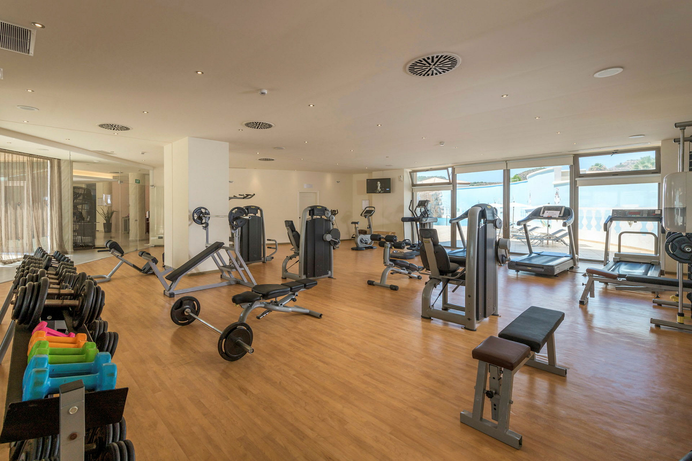 Et fitnesscenter med træningsmaskiner, vægte og løbebånd. (AI-genereret tekst)