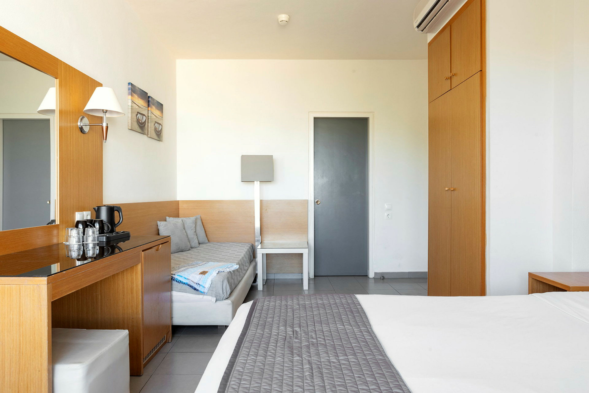 Et hotelværelse med seng, garderobe og skrivebord. (AI-genereret tekst)