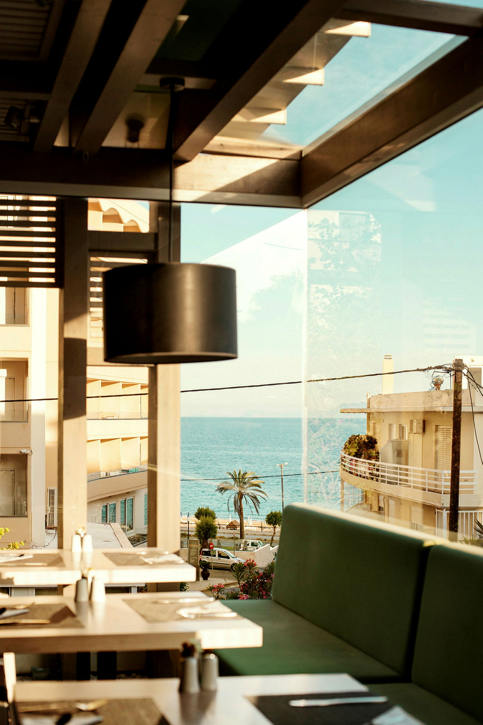 Udsigt fra restaurant med siddepladser indendørs og havet i baggrunden. (AI-genereret tekst)