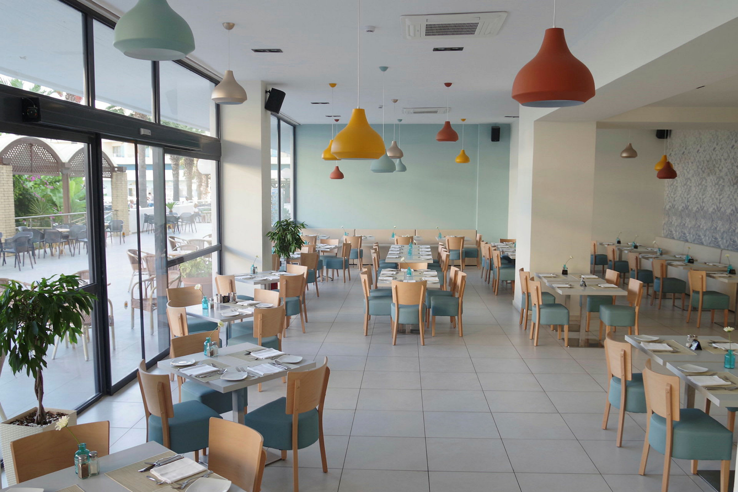 En lys og moderne restaurant med borde og stole opstillet. (AI-genereret tekst)