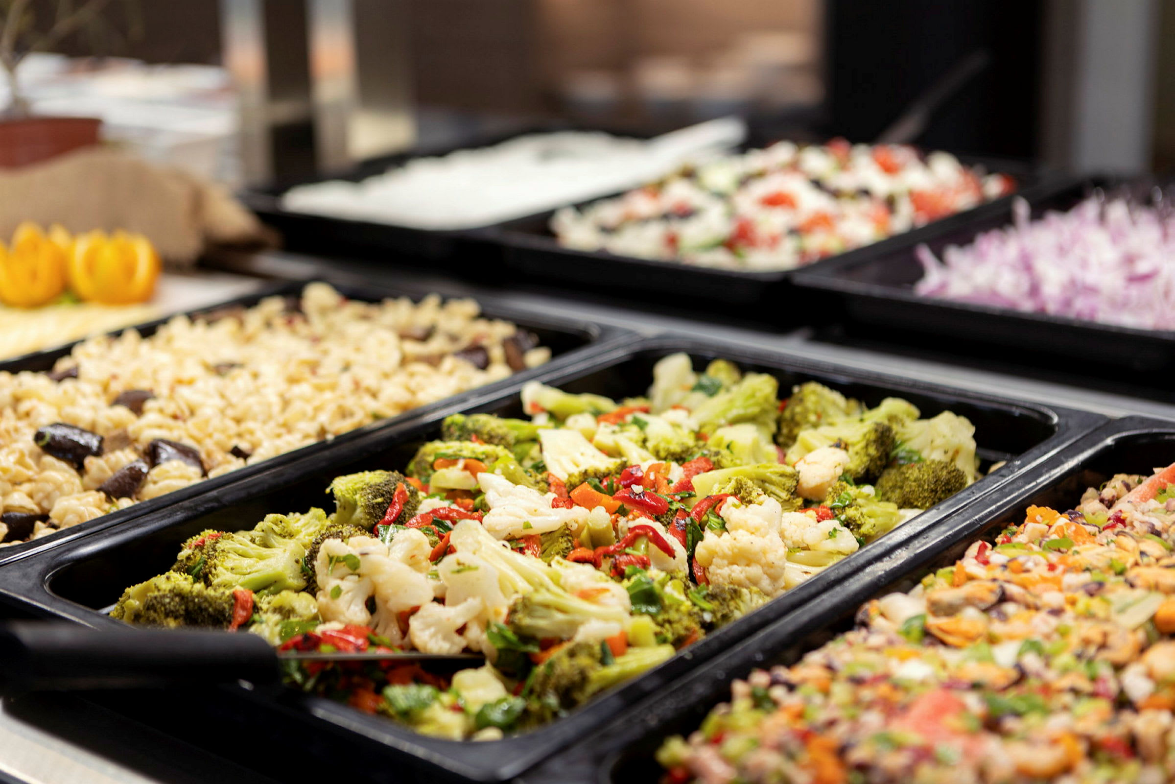 Buffet med forskellige retter såsom pasta og grøntsager. (AI-genereret tekst)