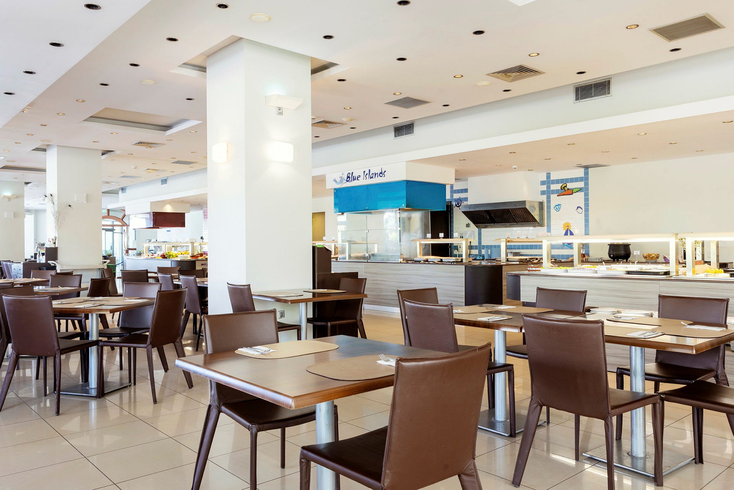 Restaurant med moderne borde og stole samt en serveringsområde i baggrunden. (AI-genereret tekst)