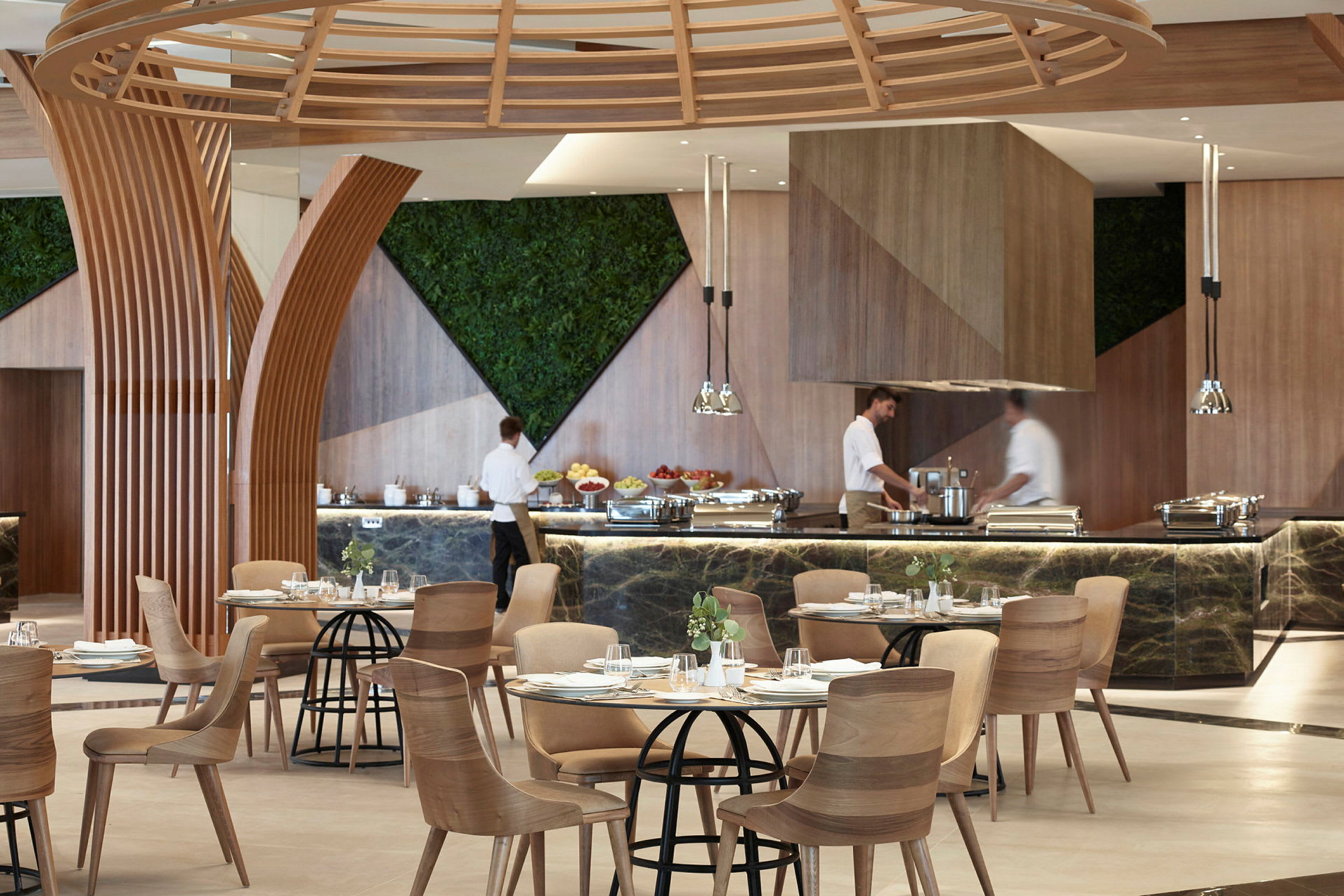 En restaurant med moderne trædetaljer og planter på væggene. Mad er serveret ved en buffetdisk. (AI-genereret tekst)