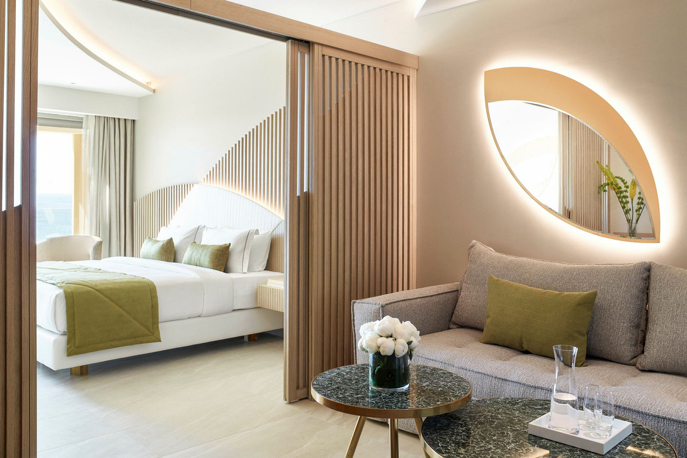 Moderne hotelværelse med sofa og seng, indrettet med naturlige farver og trædetaljer. (AI-genereret tekst)