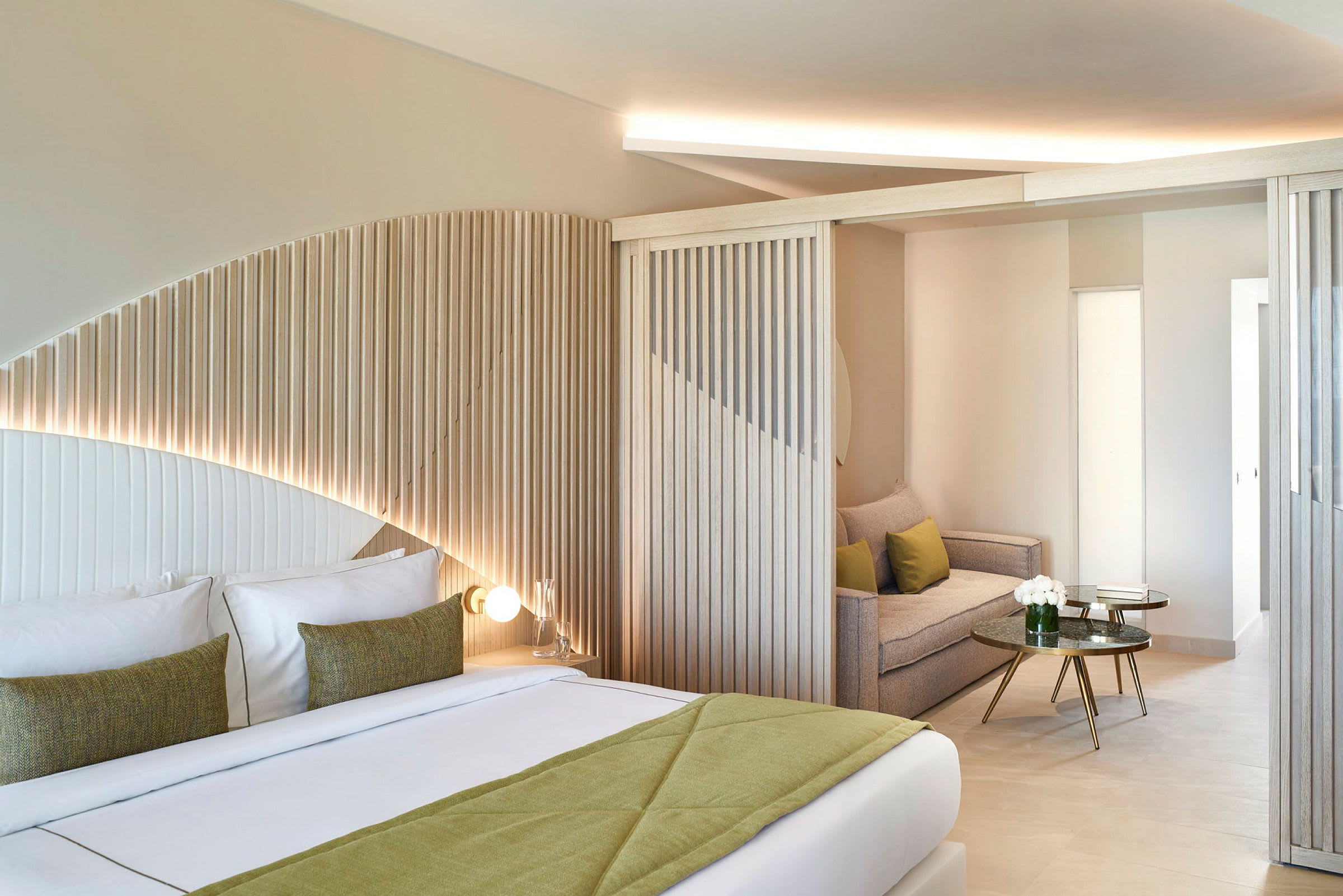 Moderne hotelværelse med afrundede træpaneler, dobbeltseng og siddeområde. (AI-genereret tekst)