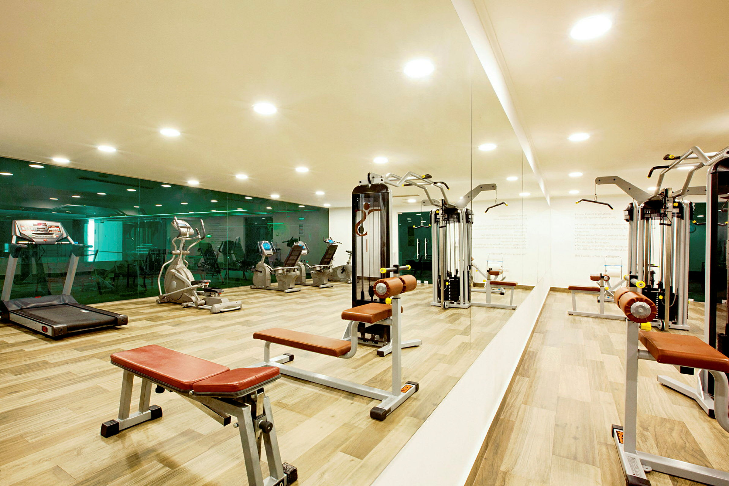 Et fitnesscenter med træningsmaskiner og spejlvæg. (AI-genereret tekst)