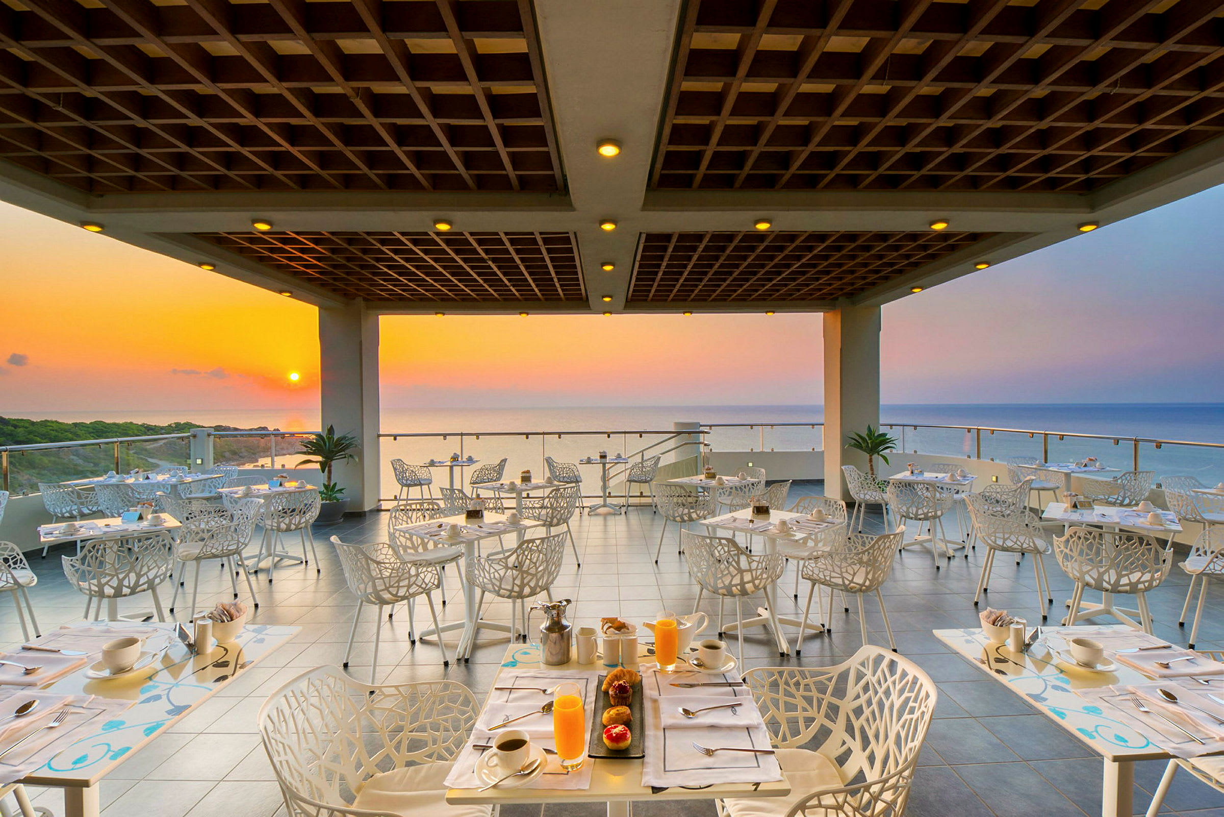 En restaurant med udsigt til havet ved solnedgang. (AI-genereret tekst)