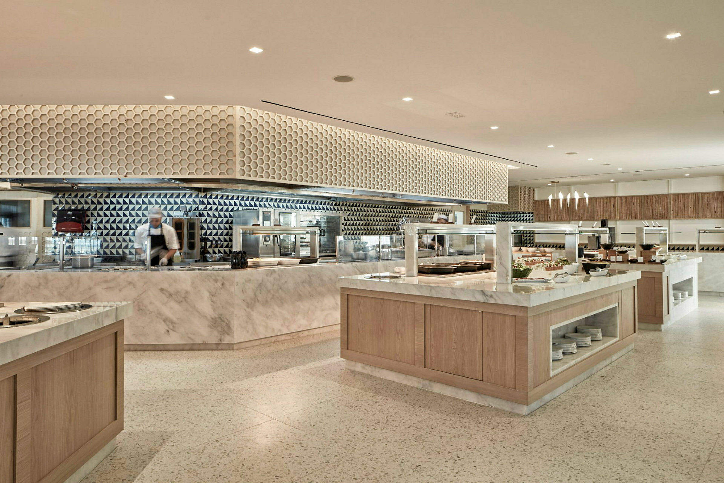 En moderne buffetrestaurant med marmorborde og geometriske vægmønstre. (AI-genereret tekst)