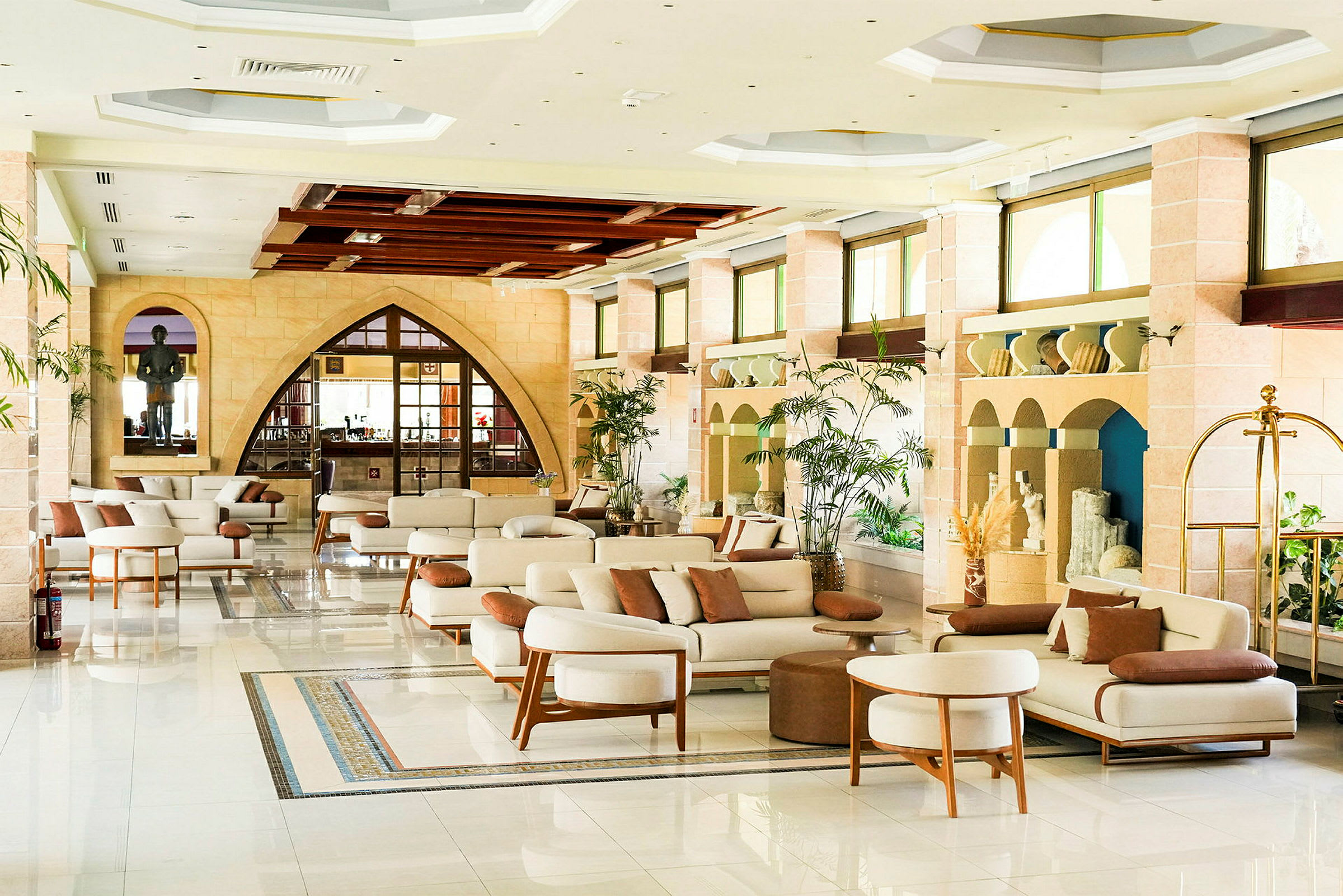 En elegant lobby med moderne møbler, planter og store vinduer. (AI-genereret tekst)